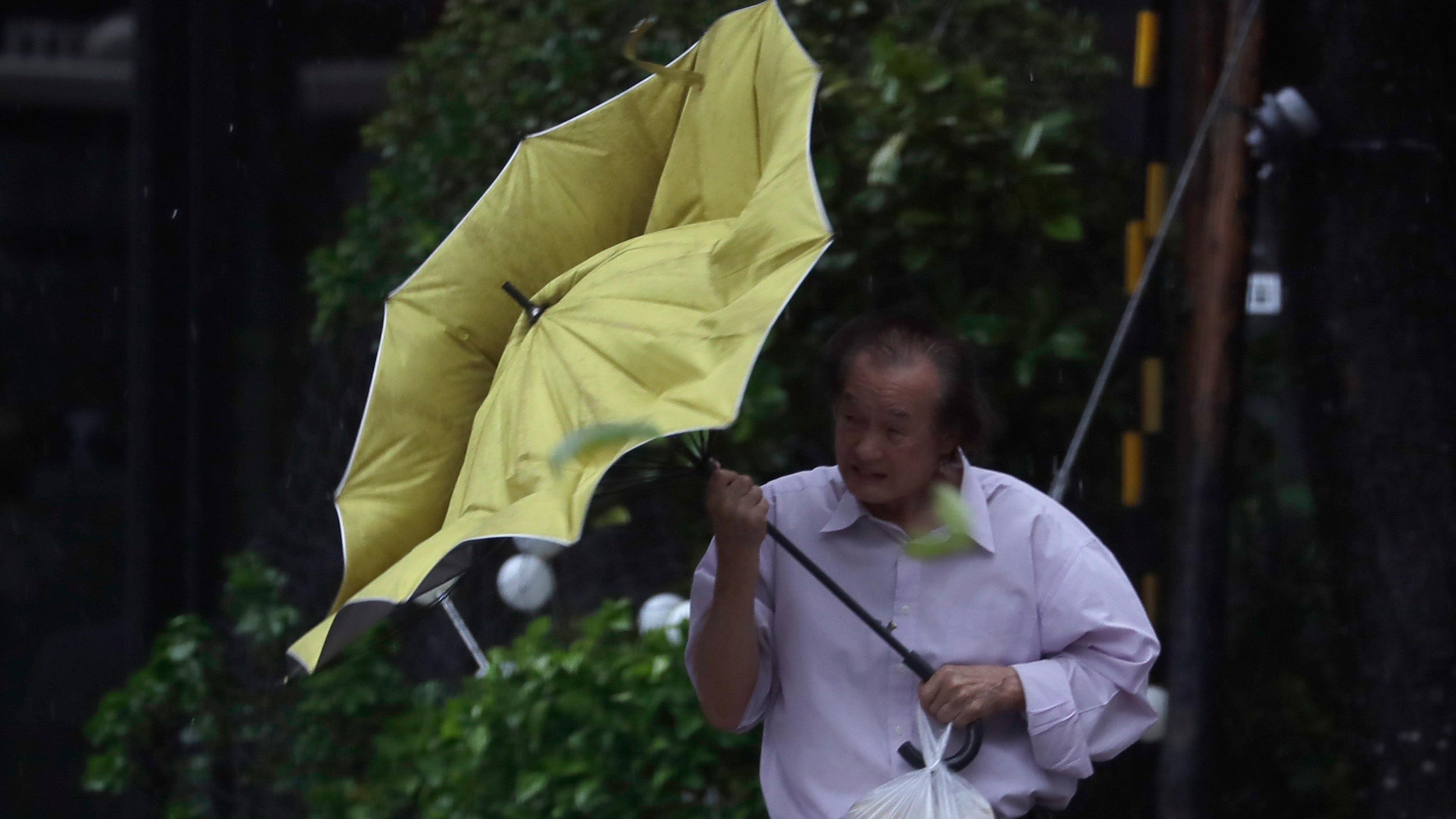 Taiwan, Taipeh: Ein Mann kämpft mit seinem Regenschirm gegen die Windböen des Taifuns "Kong-rey".