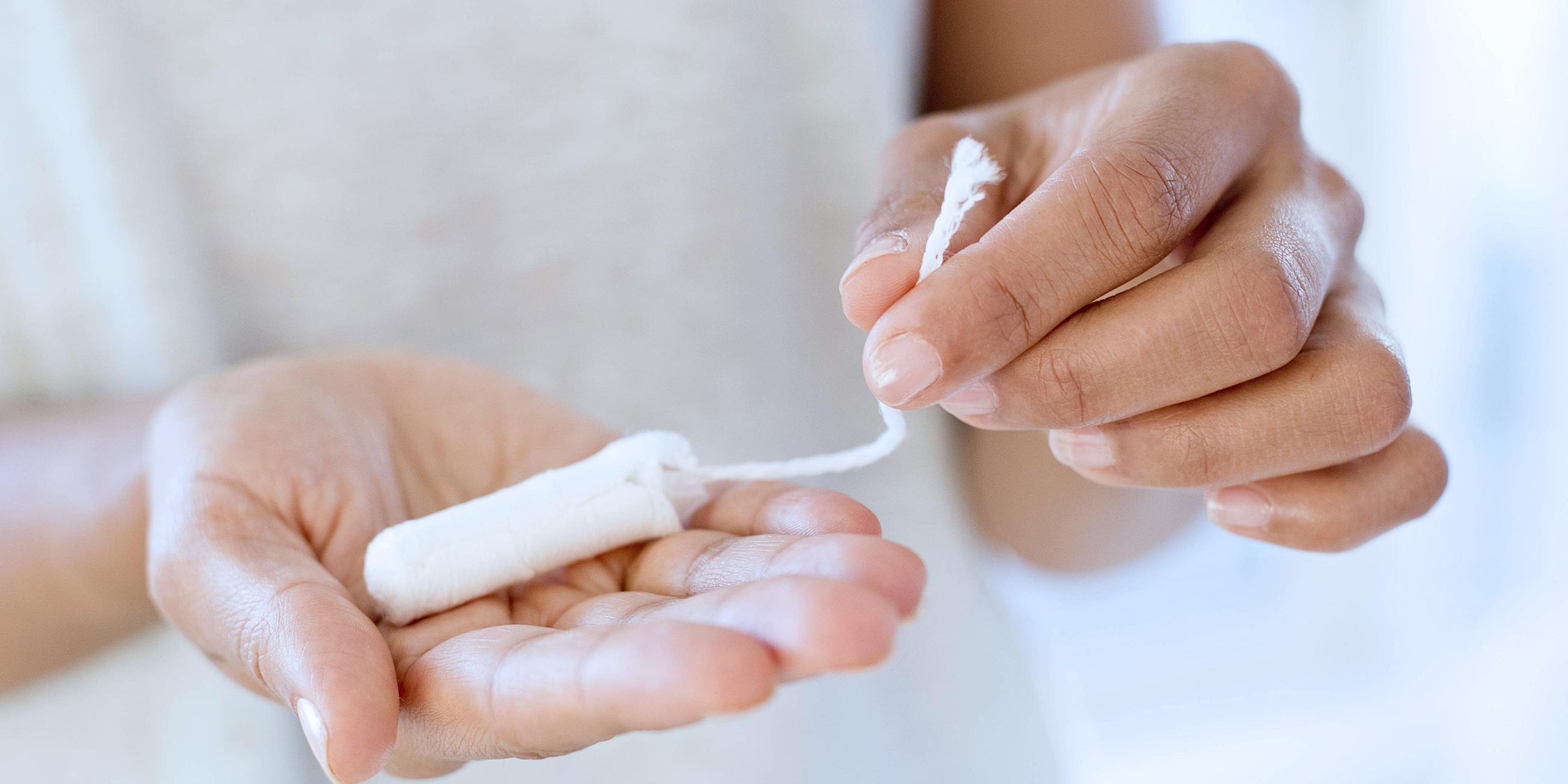 Eine Fau hält einen Tampon in der Hand