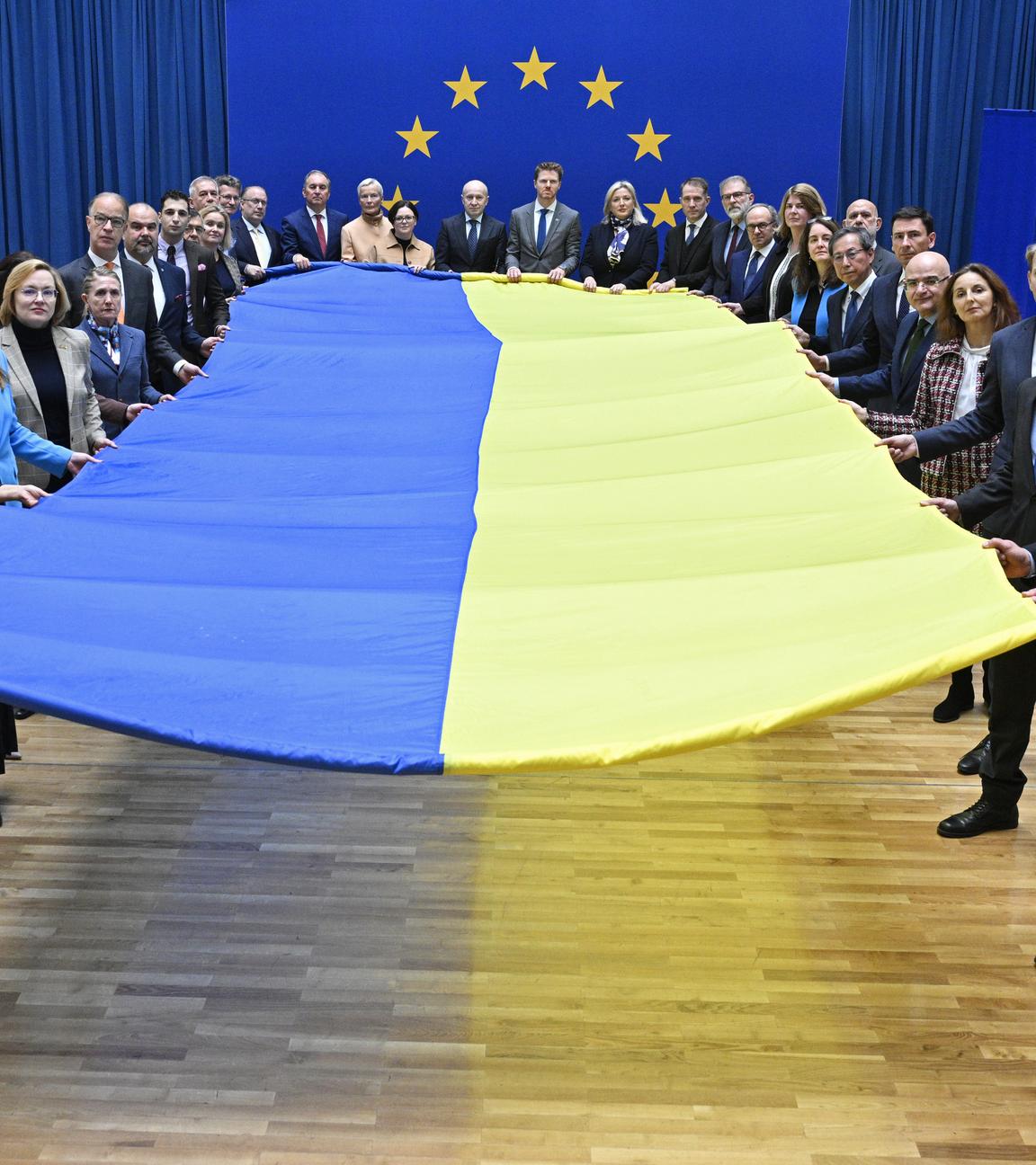 Botschafterinnen und Botschafter der EU-Staaten, der EU-Beitrittskandidaten und der G7 halten eine große Fahne beim Fototermin «1000 Tage Krieg - Solidarität mit der Ukraine» im Haus der Europäischen Union. 