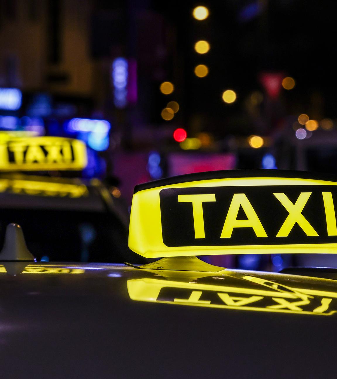 Nordrhein-Westfalen, Köln: Ein Taxi mit beleuchtetem Taxischild wartet in einer Schlange von Taxen auf Fahrgäste.