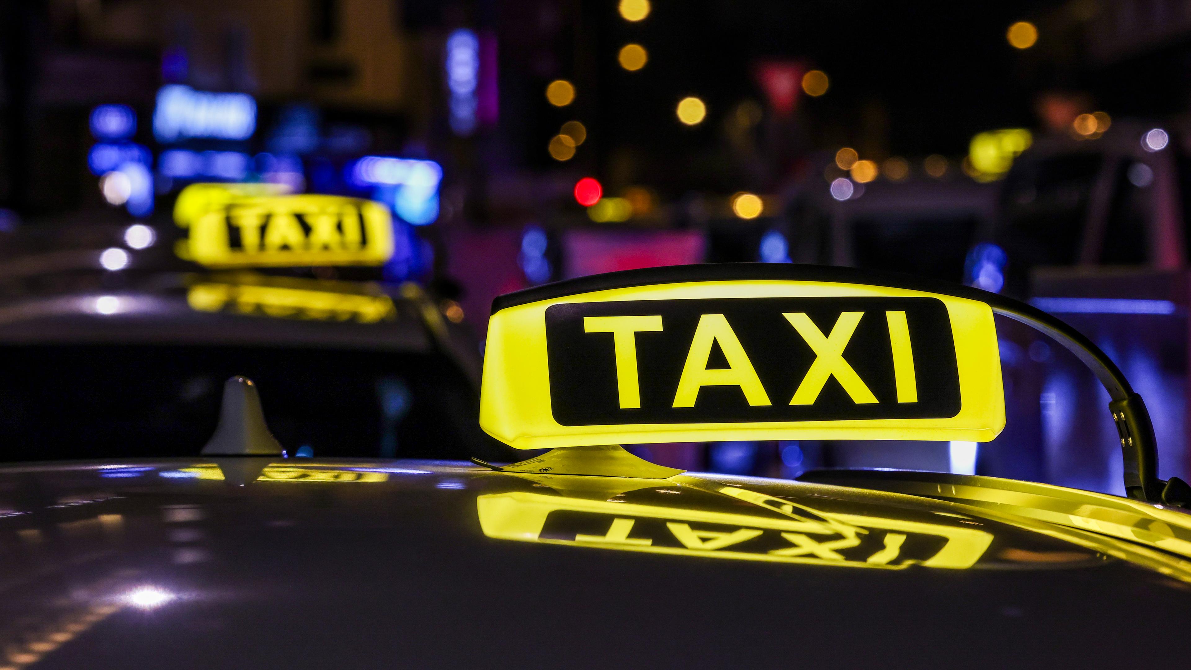 Nordrhein-Westfalen, Köln: Ein Taxi mit beleuchtetem Taxischild wartet in einer Schlange von Taxen auf Fahrgäste.