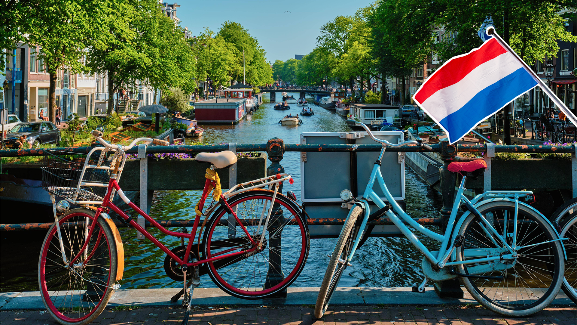 Die Niederländische Flagge vor einer Brücke in Amsterdam