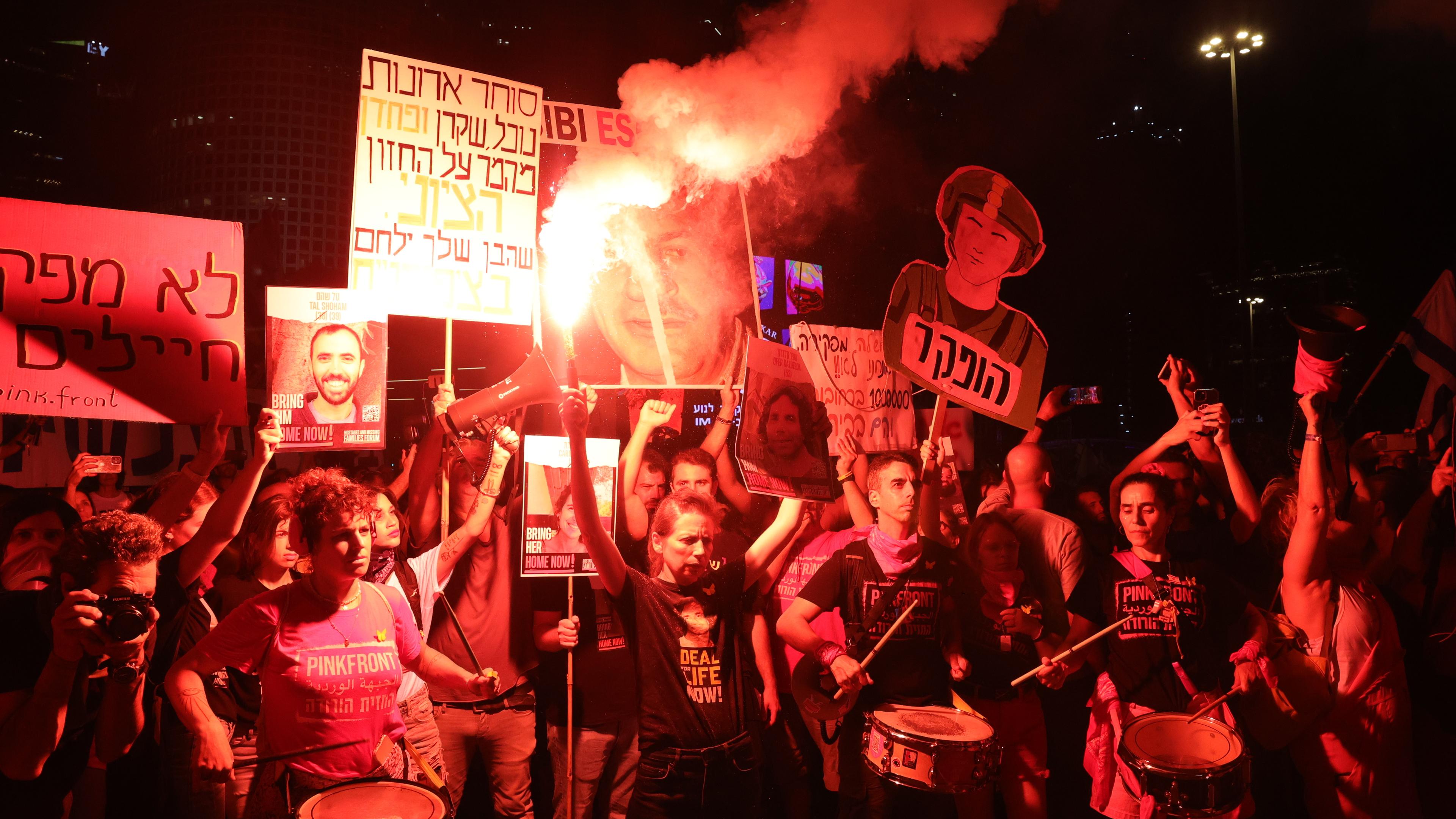 People light flares calling on the Israeli war cabinet to sign a hostage deal during a protest rally outside the Kirya military headquarters in Tel Aviv, Israel, 15 June 2024. 