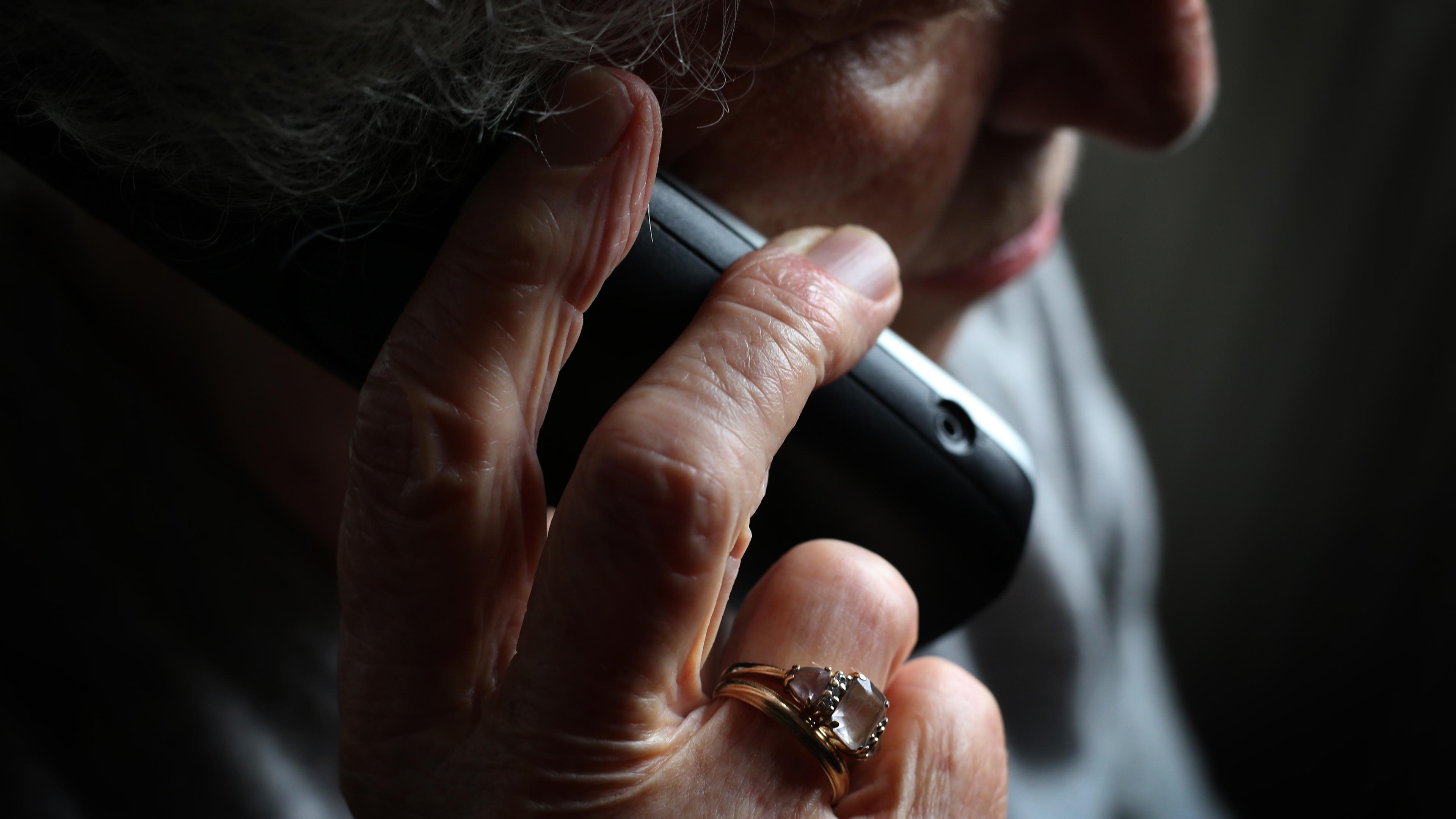 Bayern, Würzburg: Eine ältere Frau telefoniert mit einem schnurlosen Festnetztelefon.