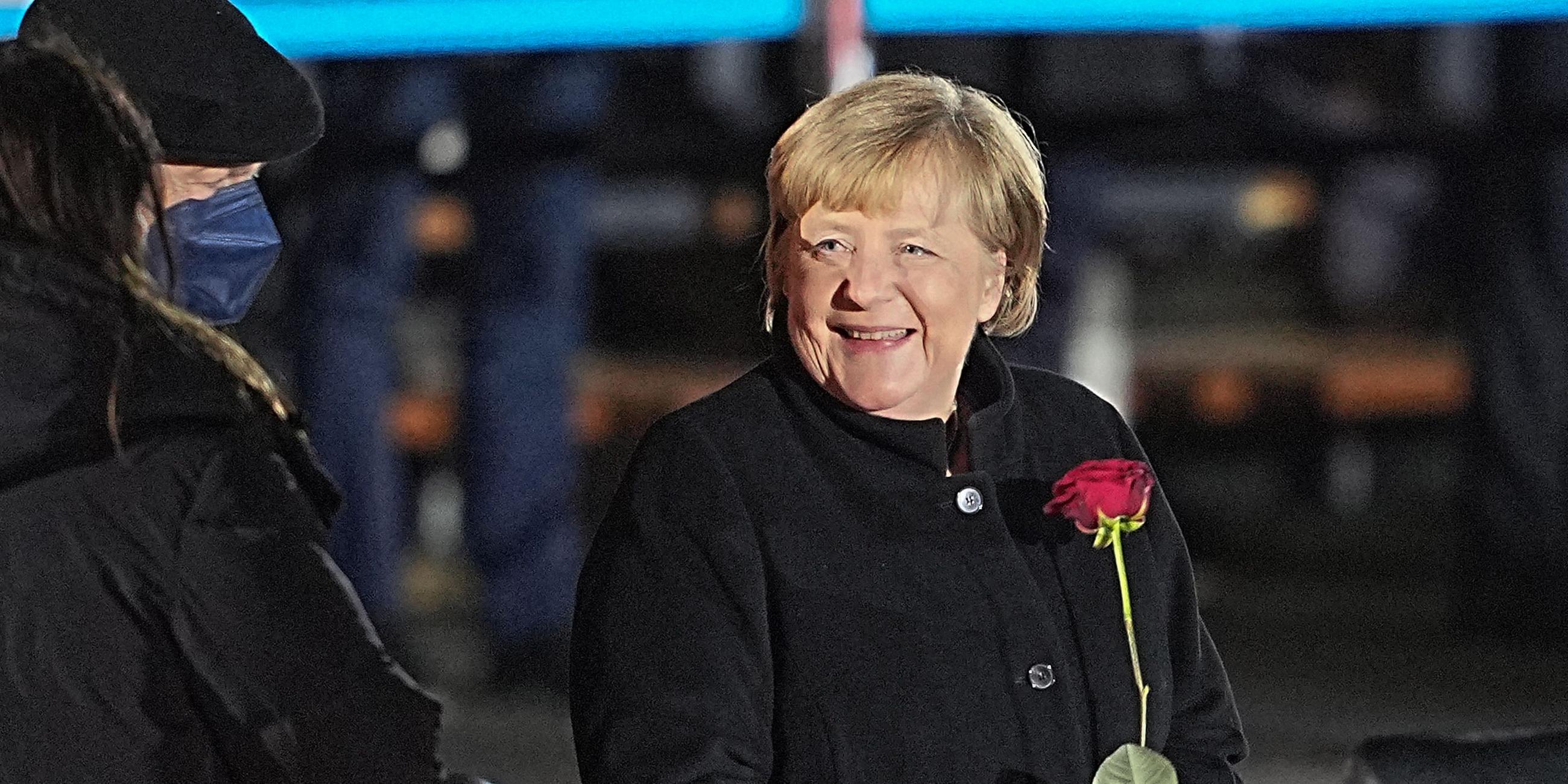 Angela Merkel mit roter Rose nach ihrem Großen Zapfenstreich.