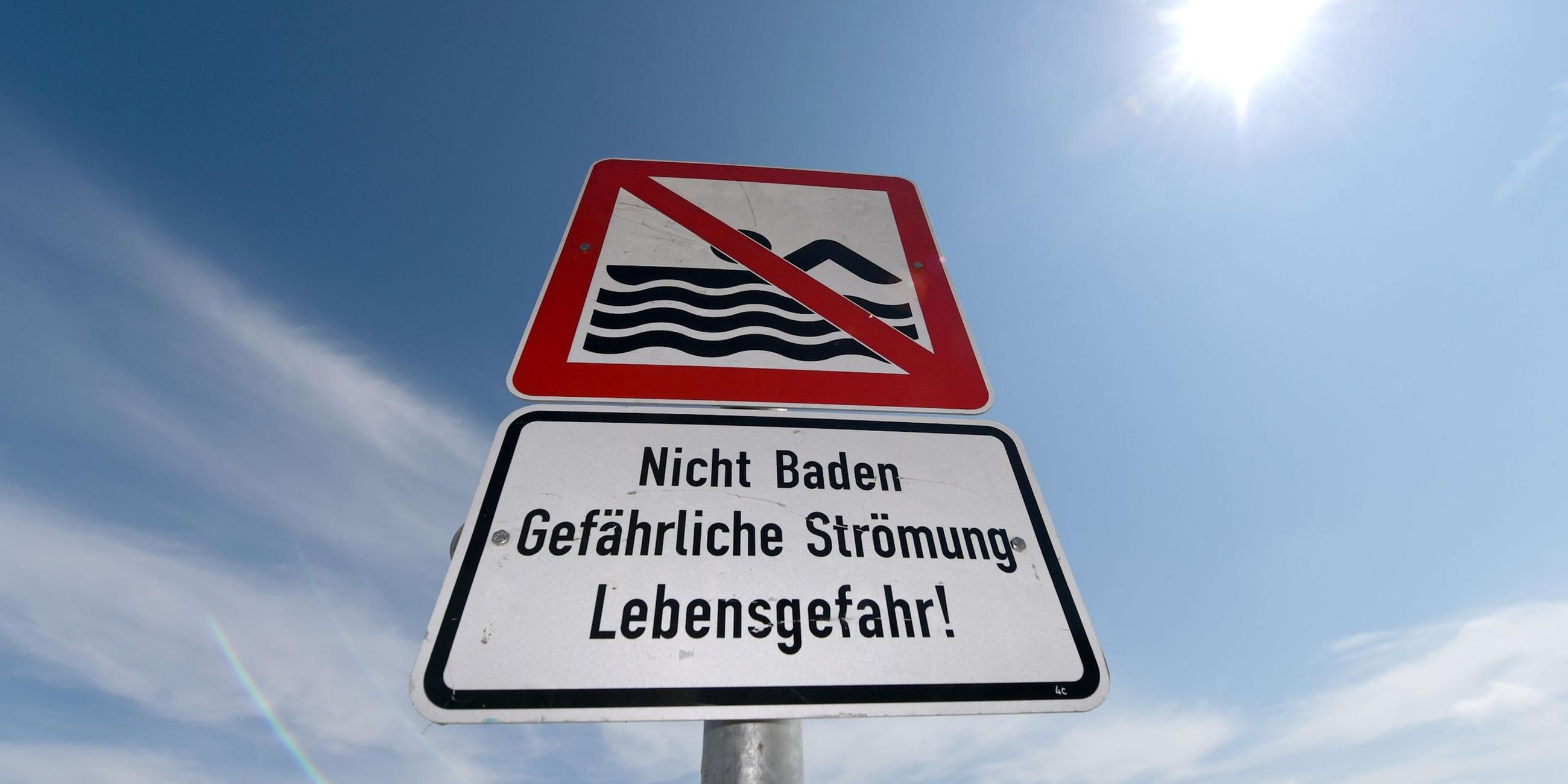 "Baden verboten"-Warnschild, das vor einer gefährlichen Strömng warnt.