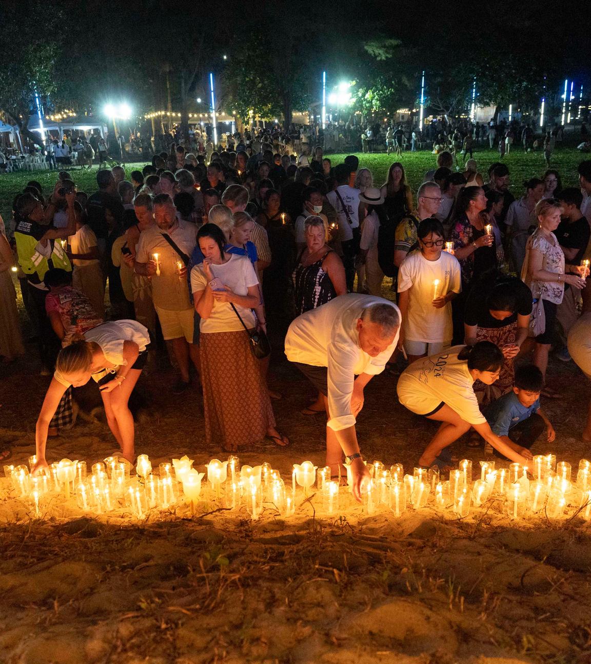 Thailand, Ban Nam Khem: Angehörige von Opfern und Überlebenden des Tsunamis im Indischen Ozean 2004 halten eine Mahnwache bei Kerzenlicht ab