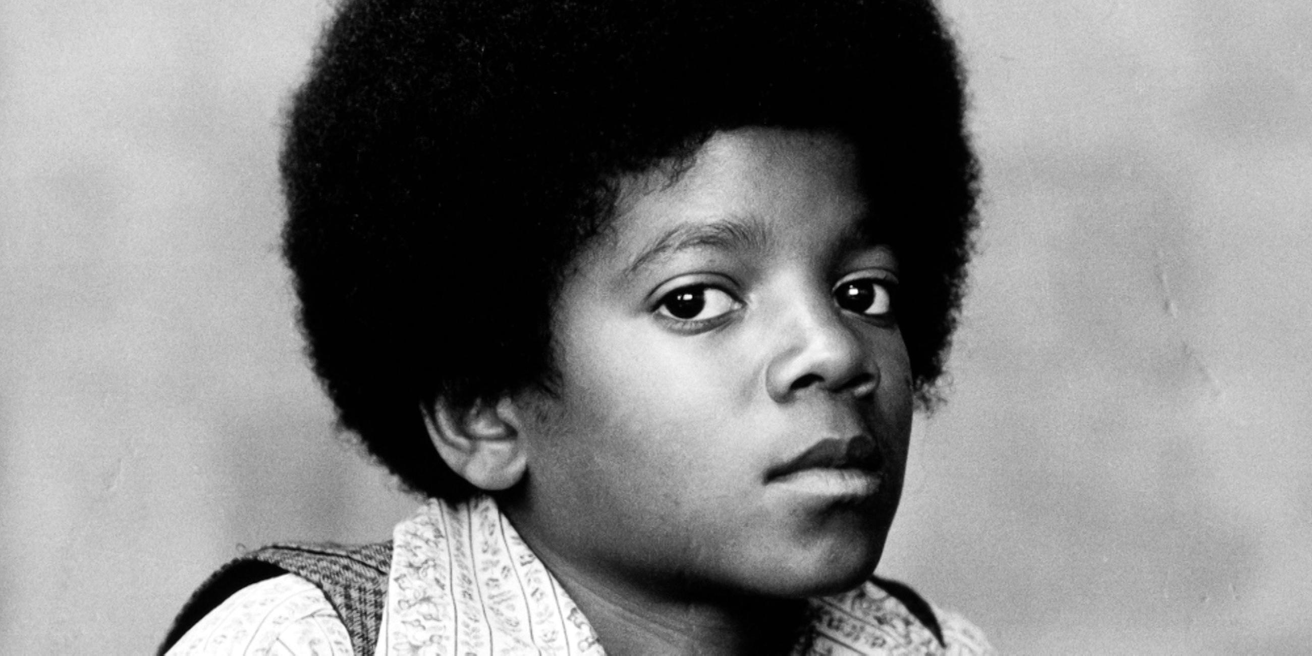  Schwarz-weißes Portraitfoto von Michael Jackson als Kind. Er blickt mit offenen Augen in die Kamera.