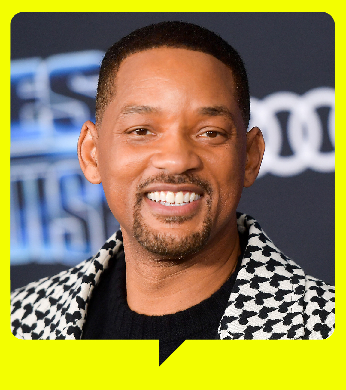 Nahaufnahme von Will Smith. Er trägt ein Hahnentritt-Sakko und lächelt in die Kamera.