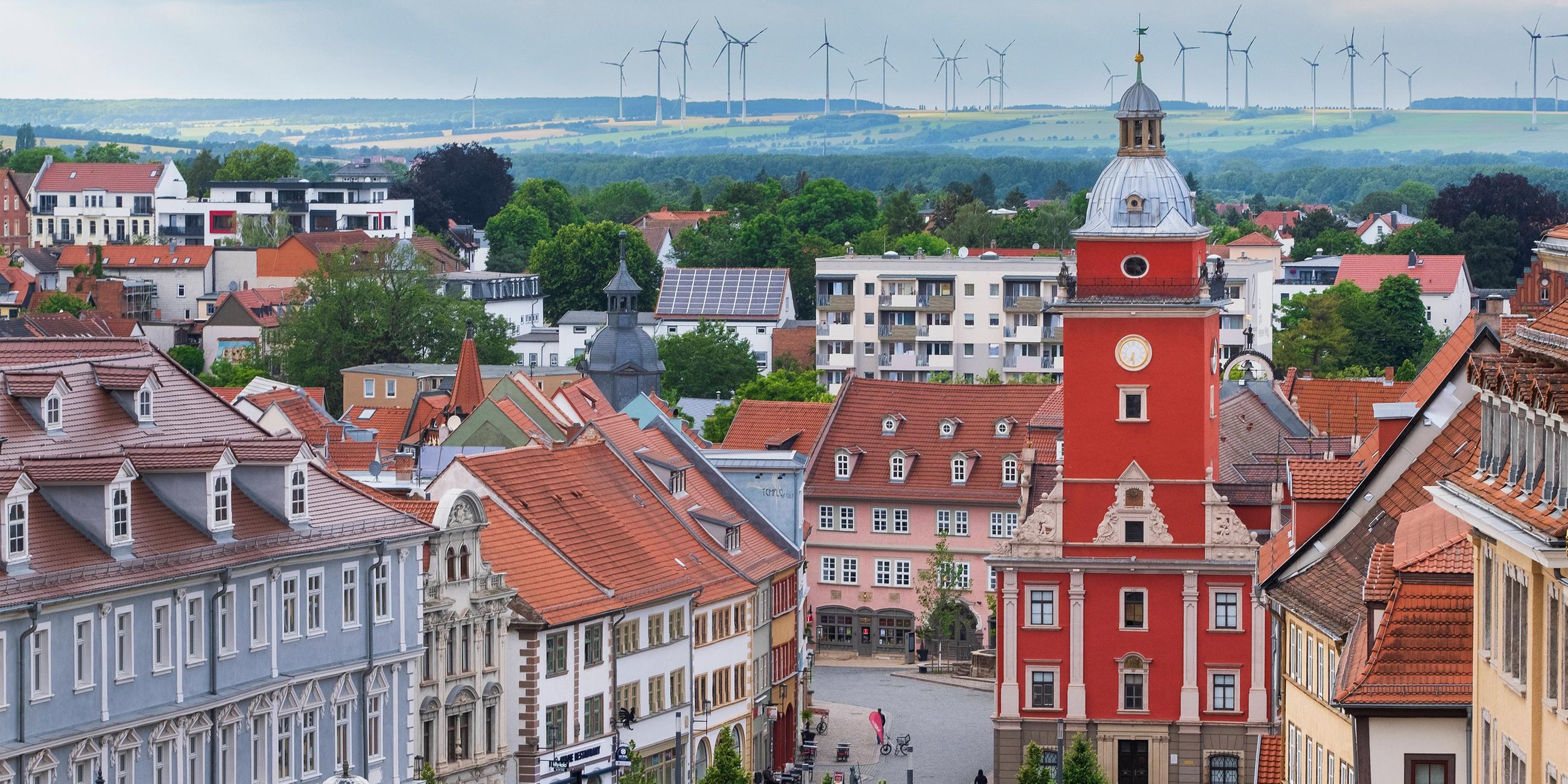 Blick vom Schloss Friedenstein auf die Altstadt von Gotha mit den historischen Rathaus. Im Hintergrund Windräder. 