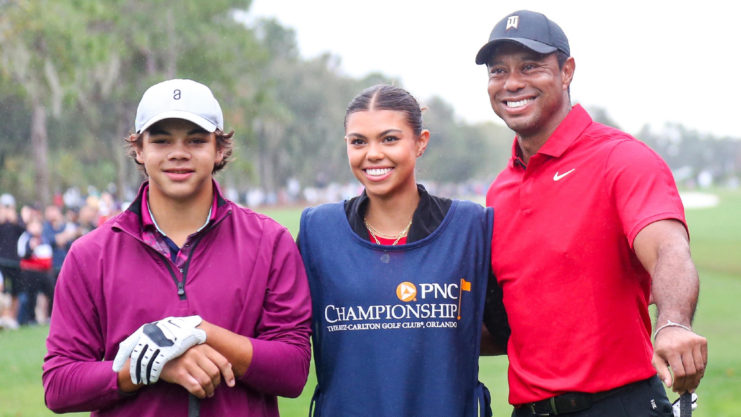 Tiger Woods, Tochter Samantha und Sohn Charlie stehen Arm in Arm auf einem Golfplatz.