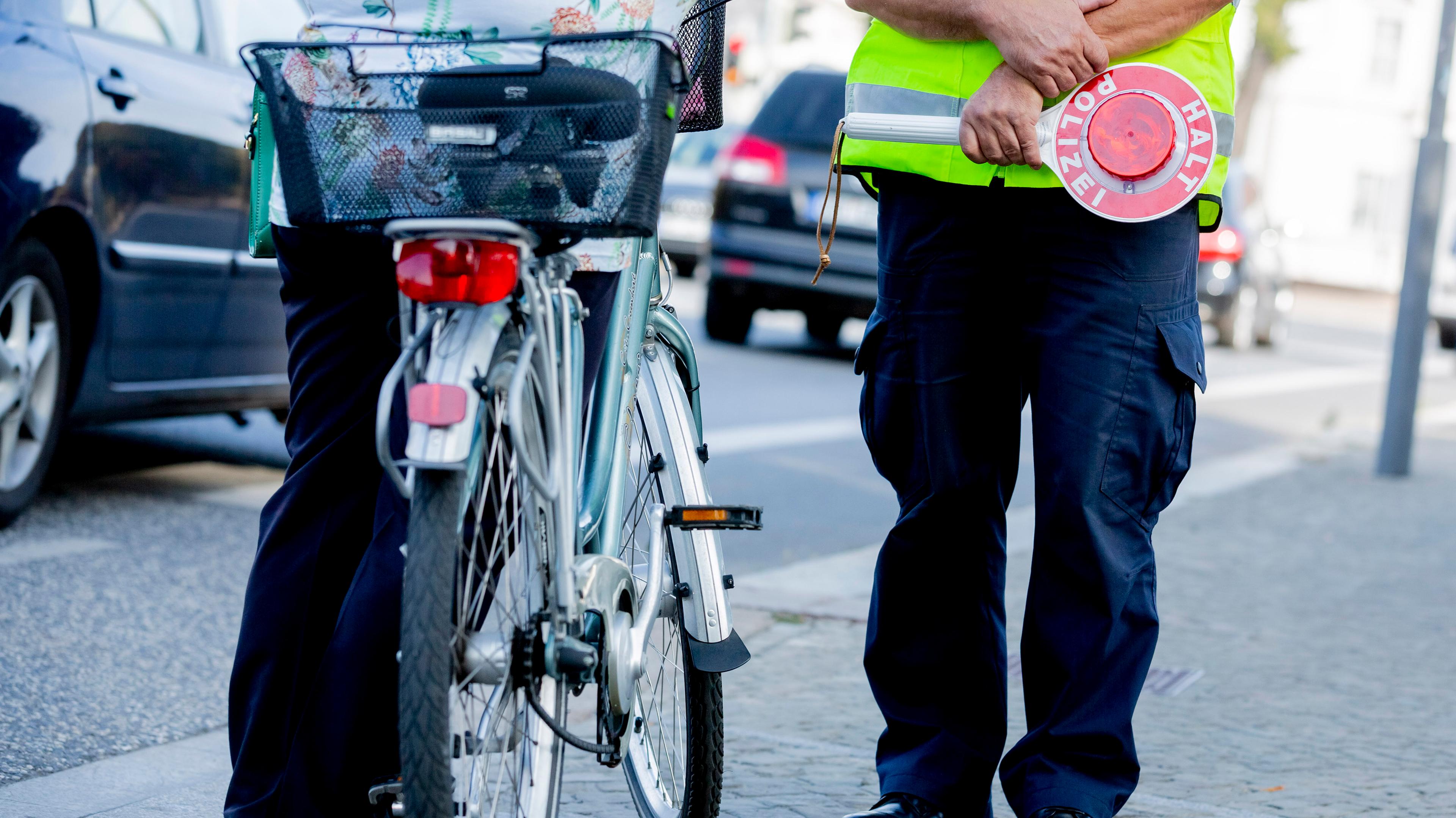 Ein Polizist kontrolliert eine Fahrradfahrerin.