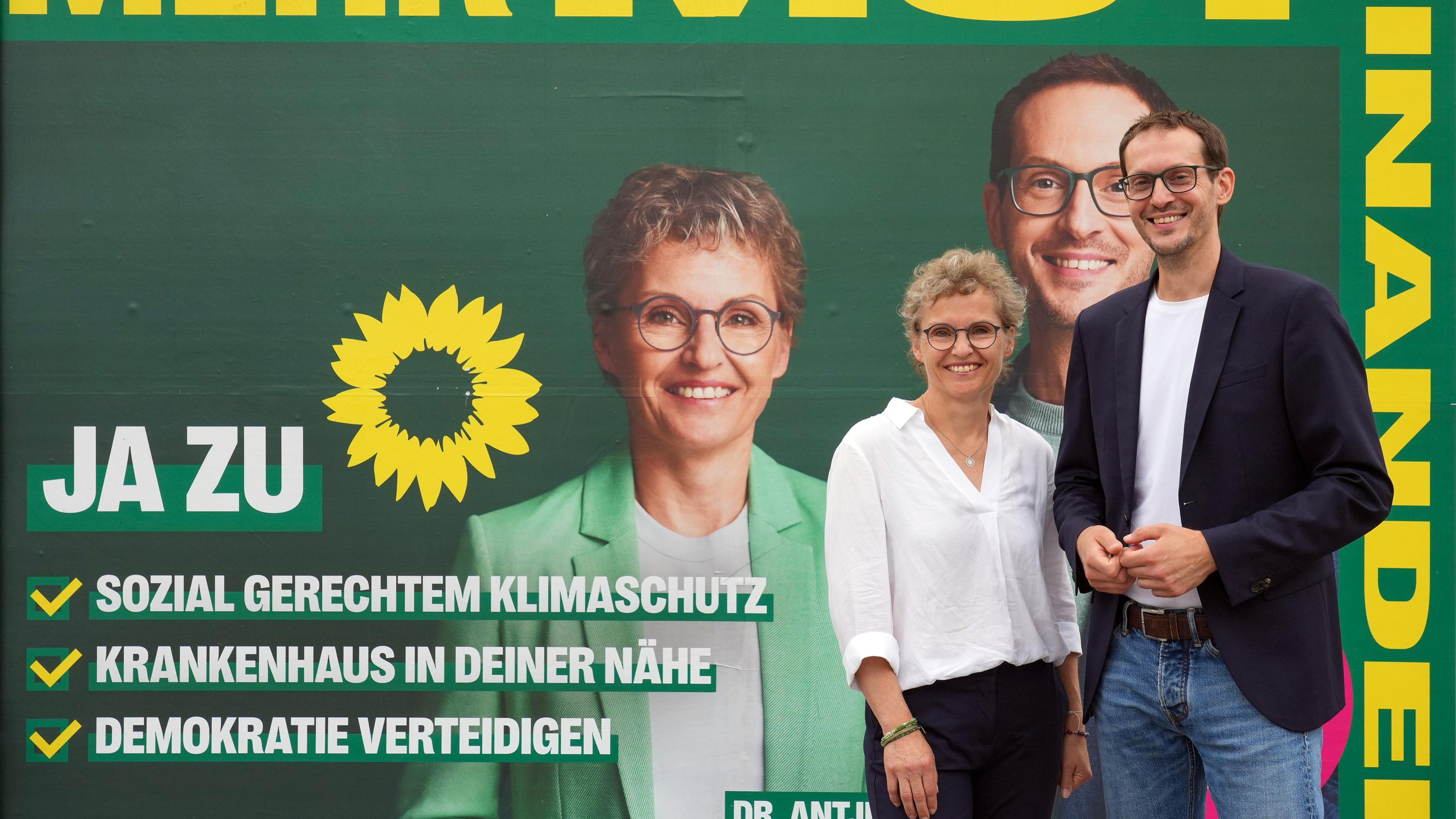 Die Grünen-Spitzenkandidaten Antje Töpfer und Benjamin Raschke stehen vor ihrem Wahlkampfplakat.