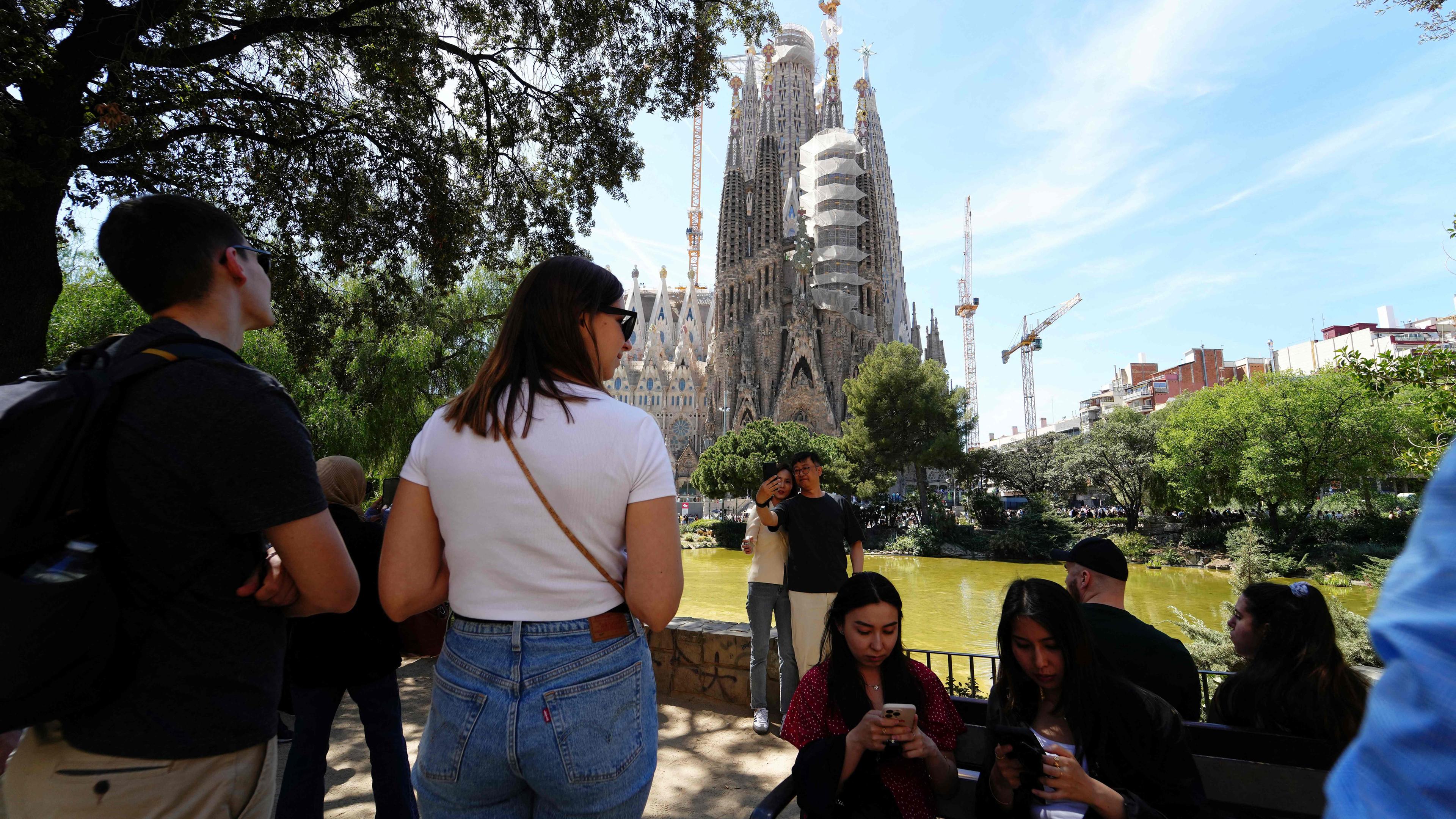 Archiv: Touristen fotografieren am 13. April 2024 mit der Basilika Sagrada Familia in Barcelona im Hintergrund.