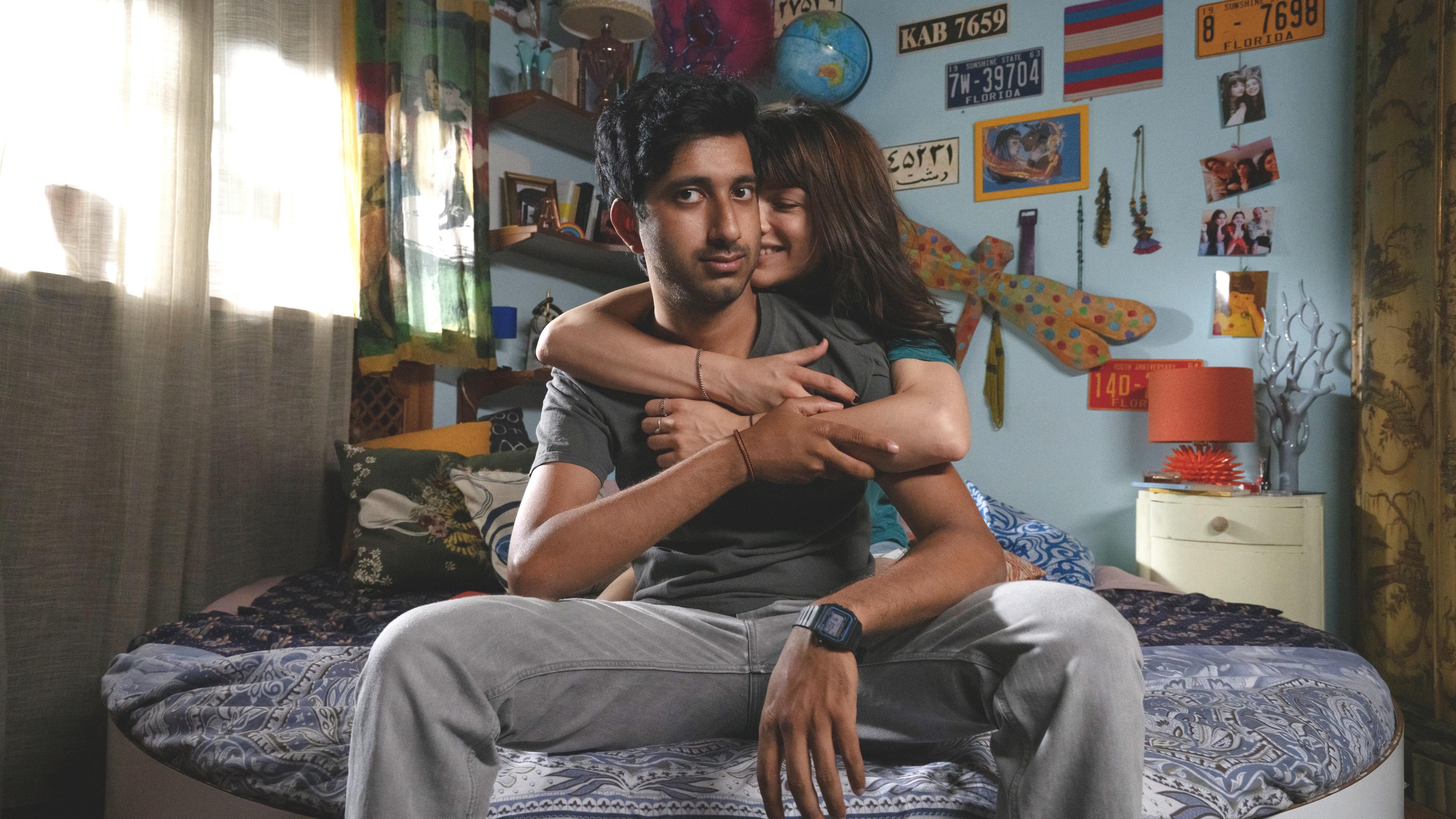 Phaim (Phaim Bhuiyan) sitzt mit seiner Freundin Asia auf dem Bett.