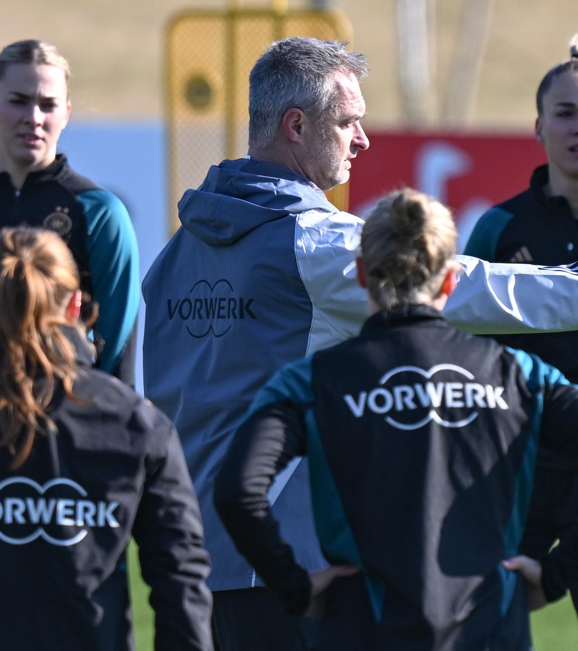 Hessen, Frankfurt/Main: Bundestrainer Christian Wück (M) spricht beim Training der Frauen-Nationalmannschaft auf dem DFB-Campus zu den Nationalspielerinnen um die neue Kapitänin Giulia Gwinn (r).