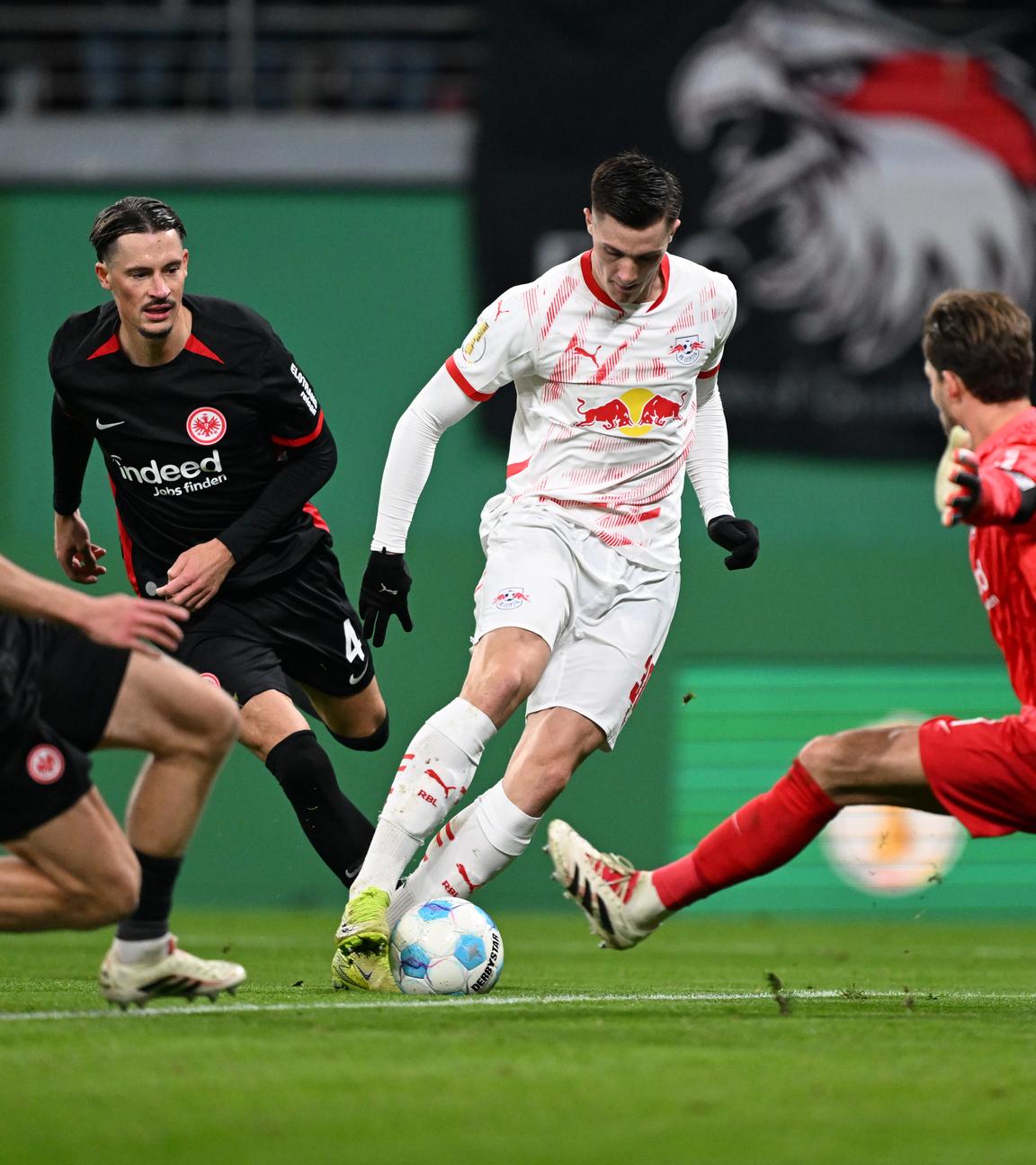 Leipzigs Benjamin Sesko (2.vr) und Frankfurts Torwart Kevin Trapp (r) in Aktion.