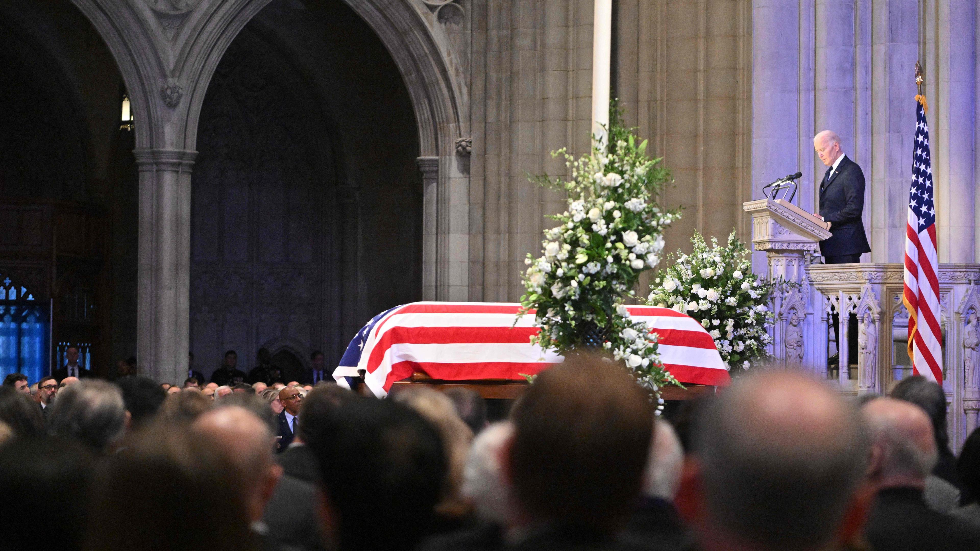 Joe Biden hält eine Trauerrede vor dem Sarg von Jimmy Carter, der mit einer US-Flagge bedeckt ist.