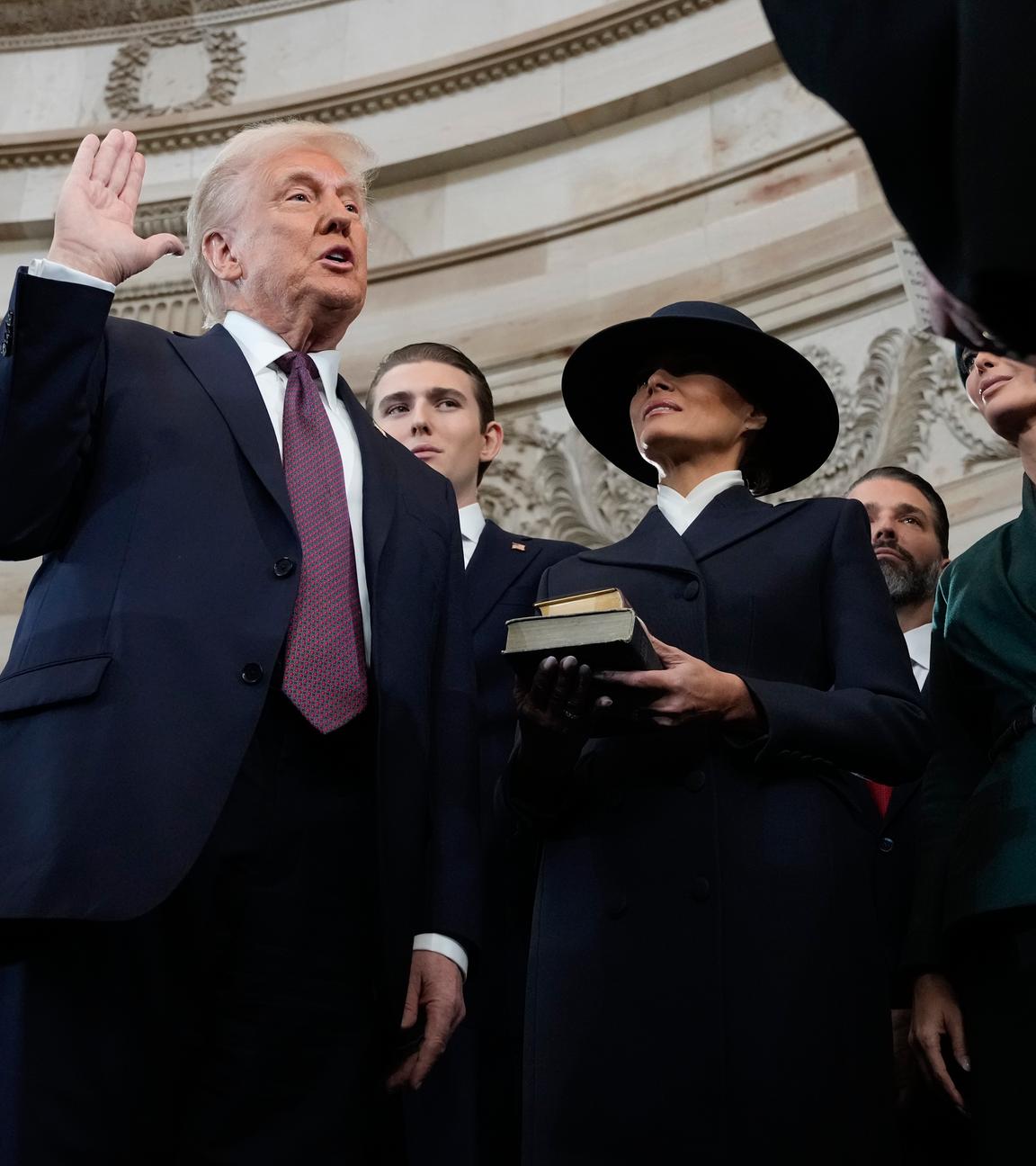 Donald Trump is sworn in as the 47th president of the United States by Chief Justice John Roberts as Melania Trump holds the Bible during the 60th Presidential Inauguration in the Rotunda of the U.S. Capitol in Washington