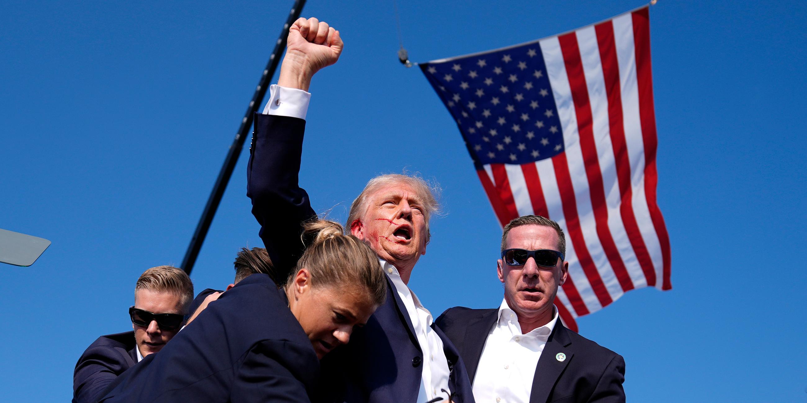 Donald Trump erhebt die Faust vor einer US-Flagge