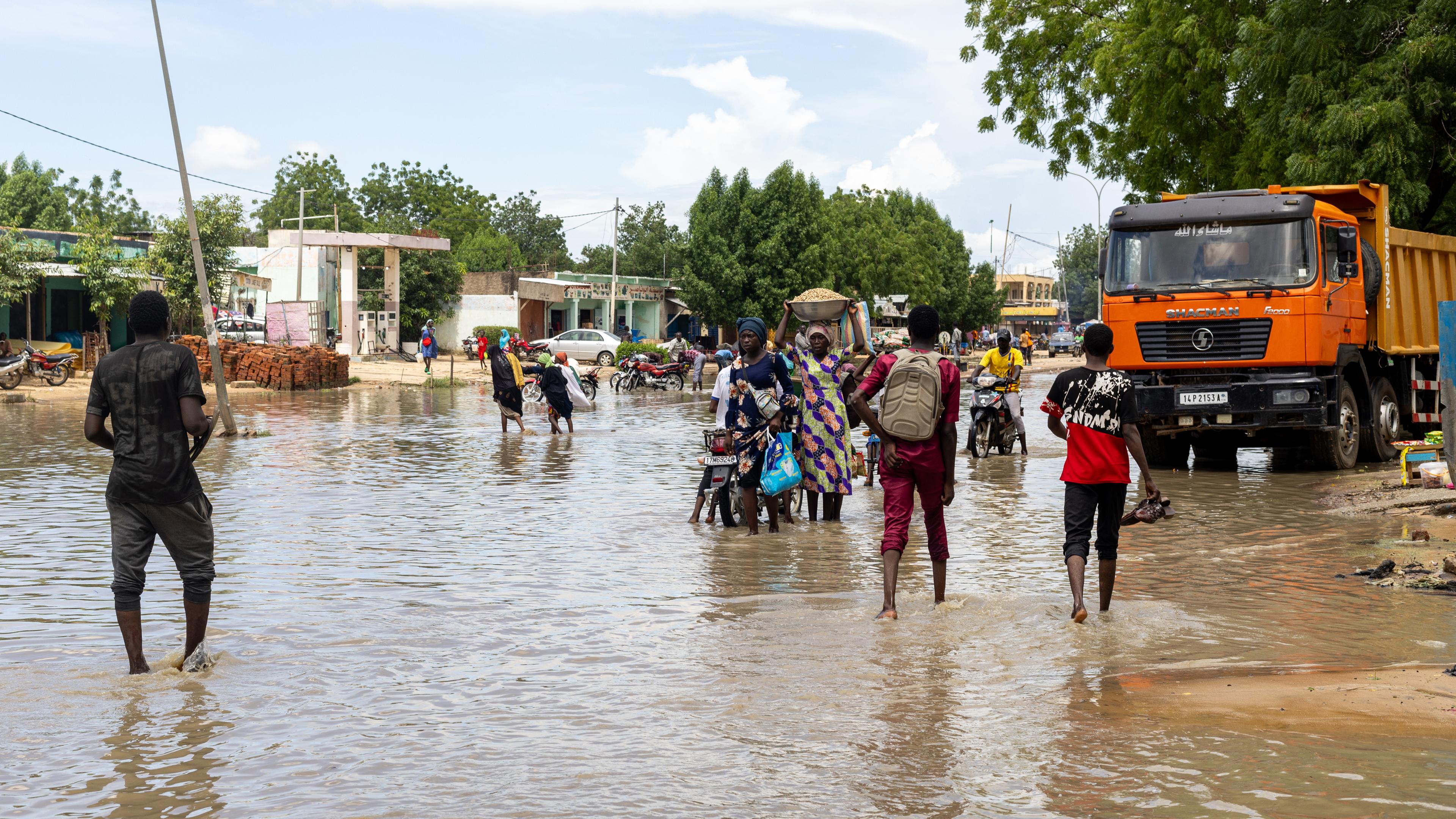 Menschen gehen auf einer überfluteten Straße in N'Djamena, Tschad