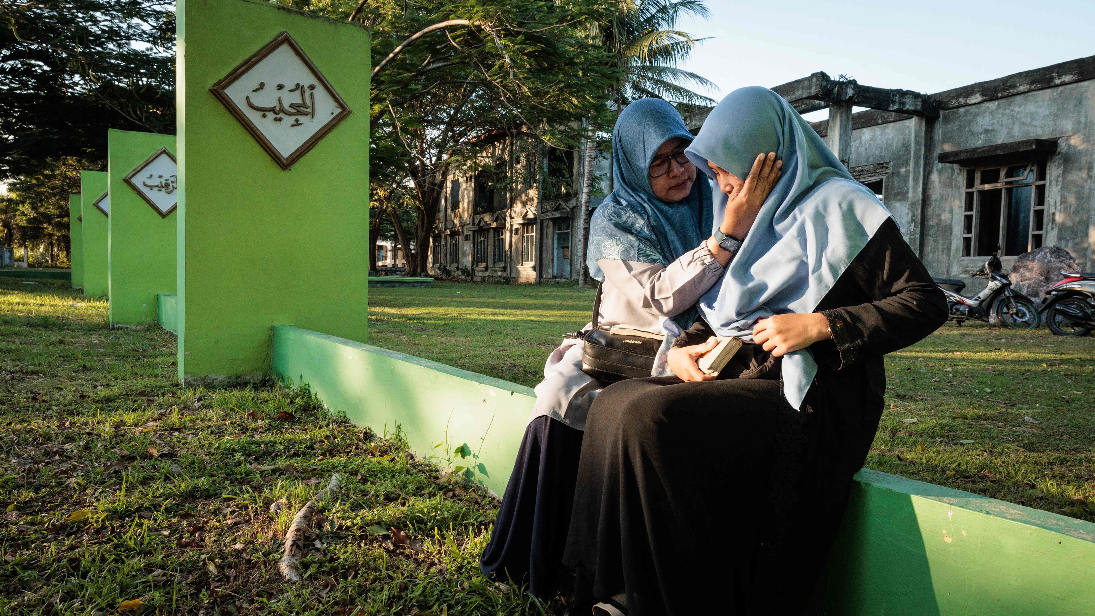 Nita tröstet ihre Tochter Aisha nach Gebeten am Massengrab von Ulee Lheue, einer der beiden großen Massengräber, an denen die Opfer des Tsunamis im Indischen Ozean 2004 am 26. Dezember 2024, dem 20. Jahrestag des Tsunamis, in Banda Aceh beigesetzt wurden . 