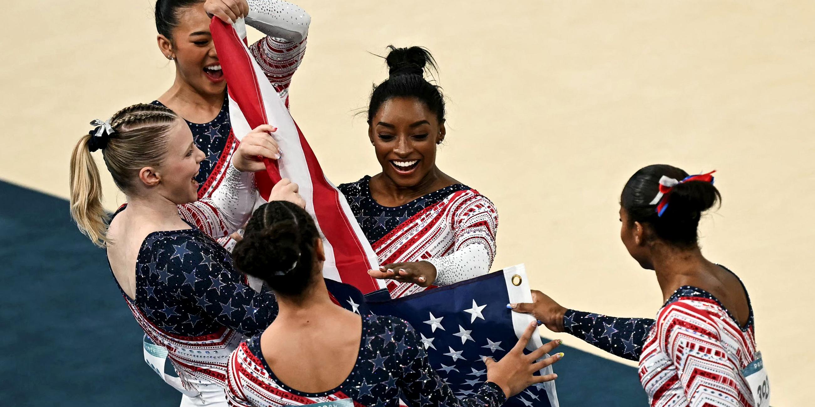 Die US-Amerikanerin Simone Biles (C) und ihre Teamkolleginnen feiern nach dem Sieg der USA.