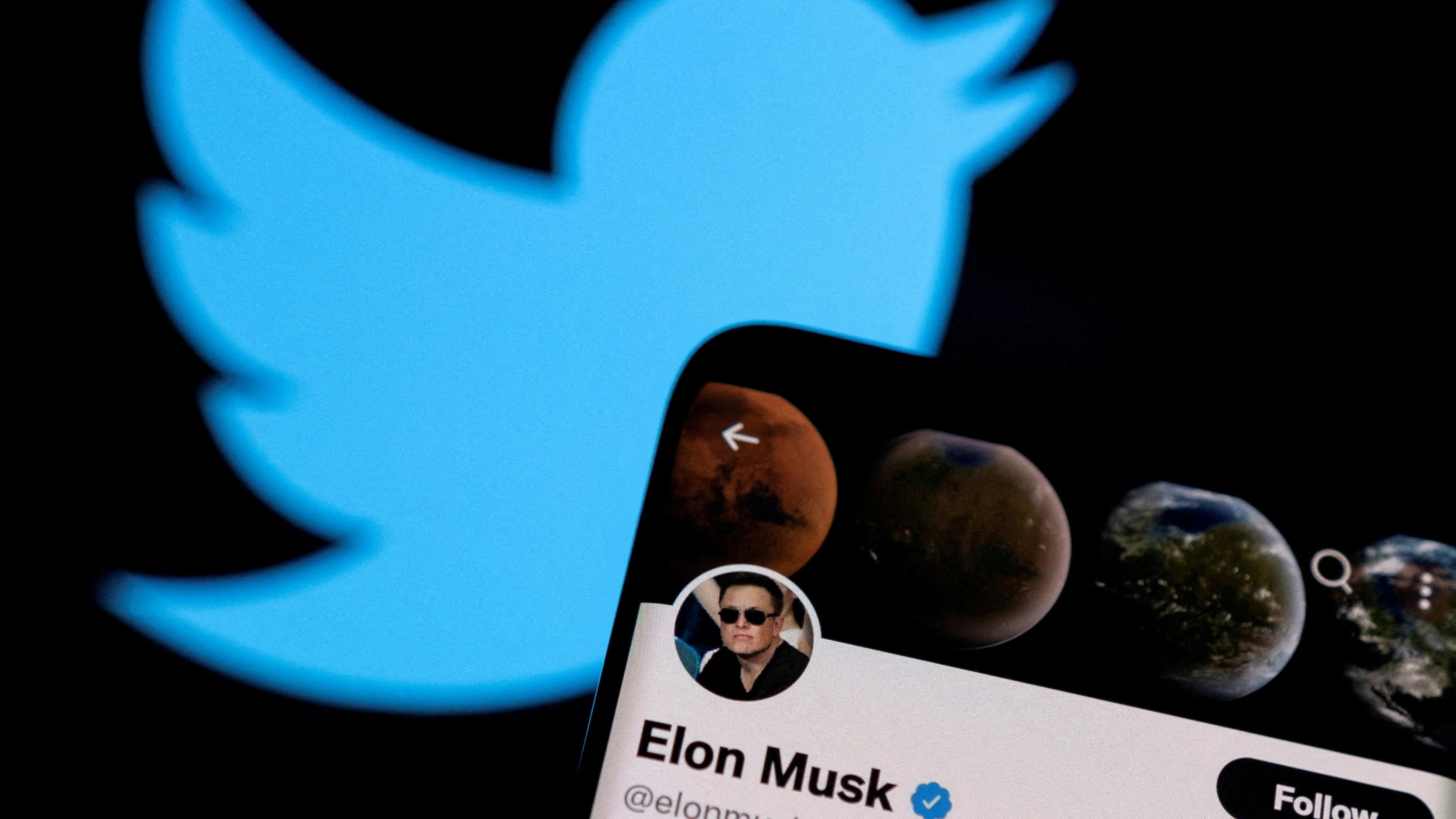 Im Vordergrund auf einem Handydisplay das Twitter-Profil von Elon Musk. Im Hintergrund das Logo von Twitter.