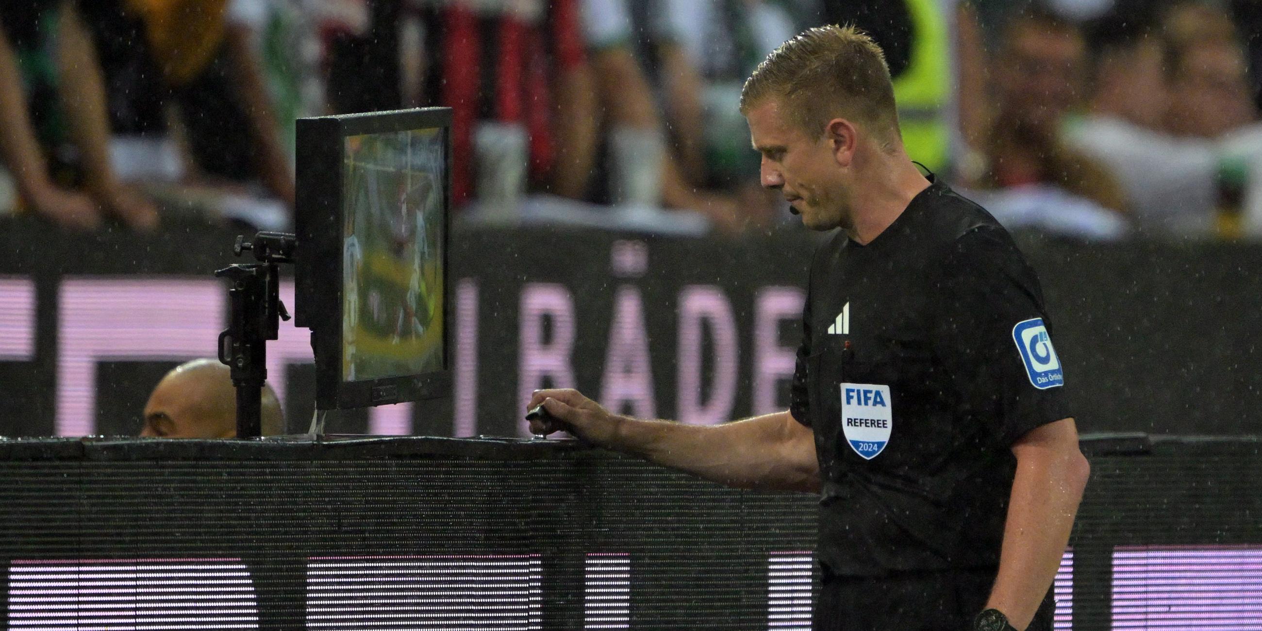 Im Spiel Mönchengladbach gegen Leverkusen prüft Schiedsrichter Robert Schröder einen möglichen Strafstoß per Videobeweis.