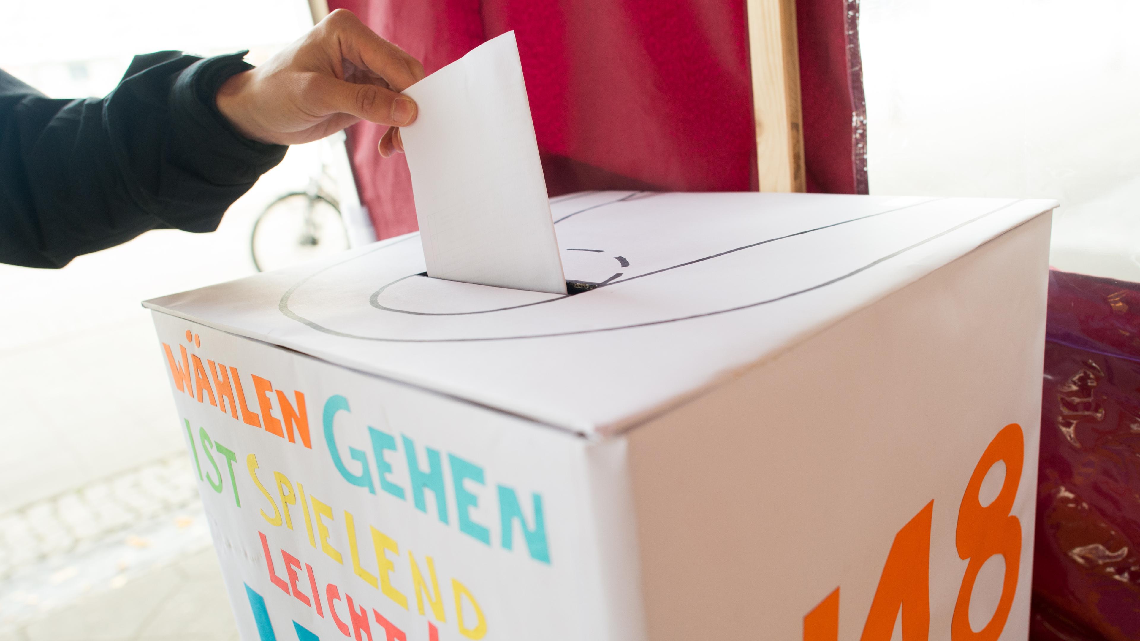  Ein Jugendlicher wirft für die U-18-Wahl einen Wahlzettel in eine Wahlurne