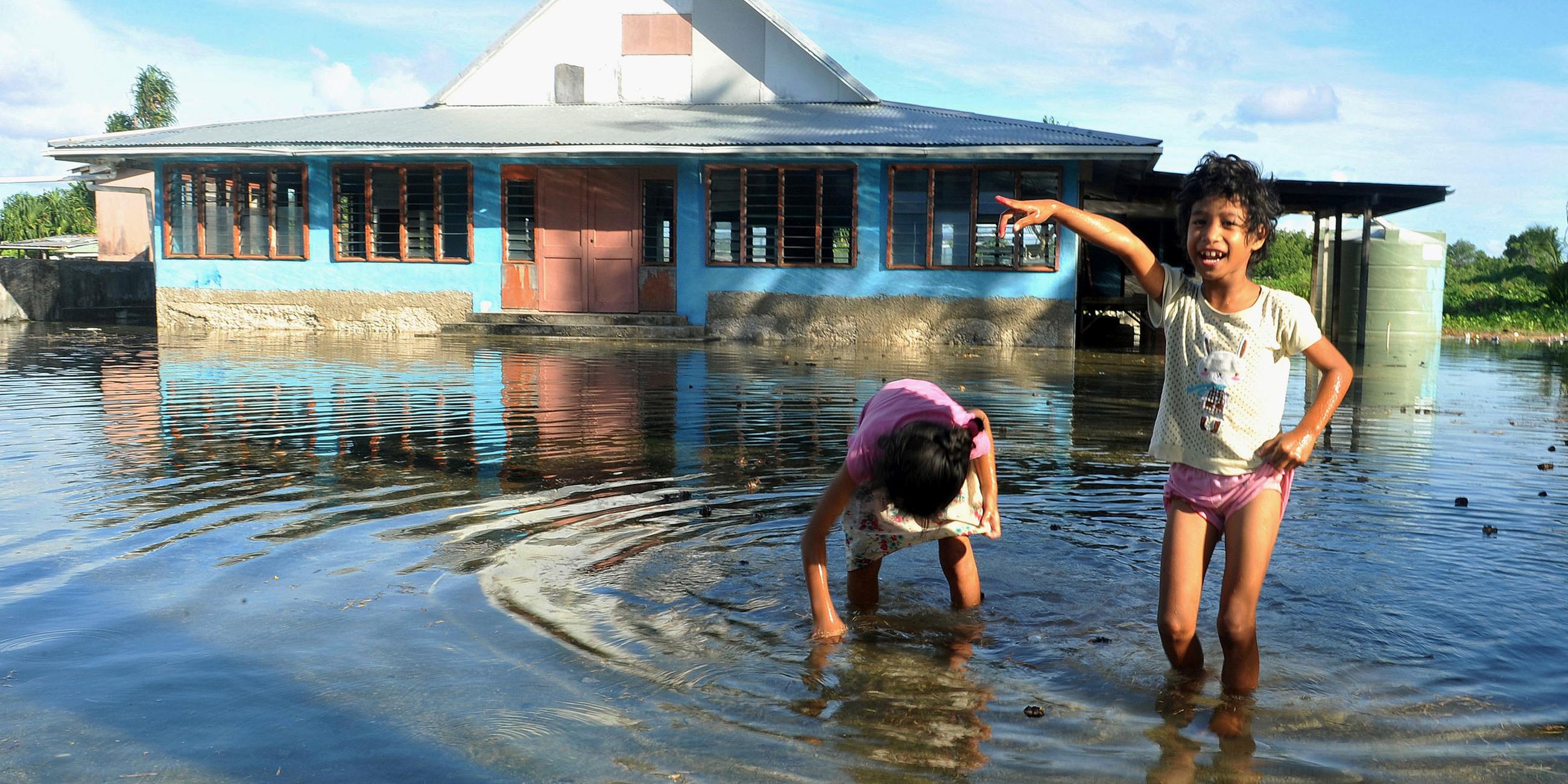 Kinder spielen am 30.01.2014 auf einem vom Meerwasser überflutetem Platz in Funafuti, der Hauptstadt von Tuvalu