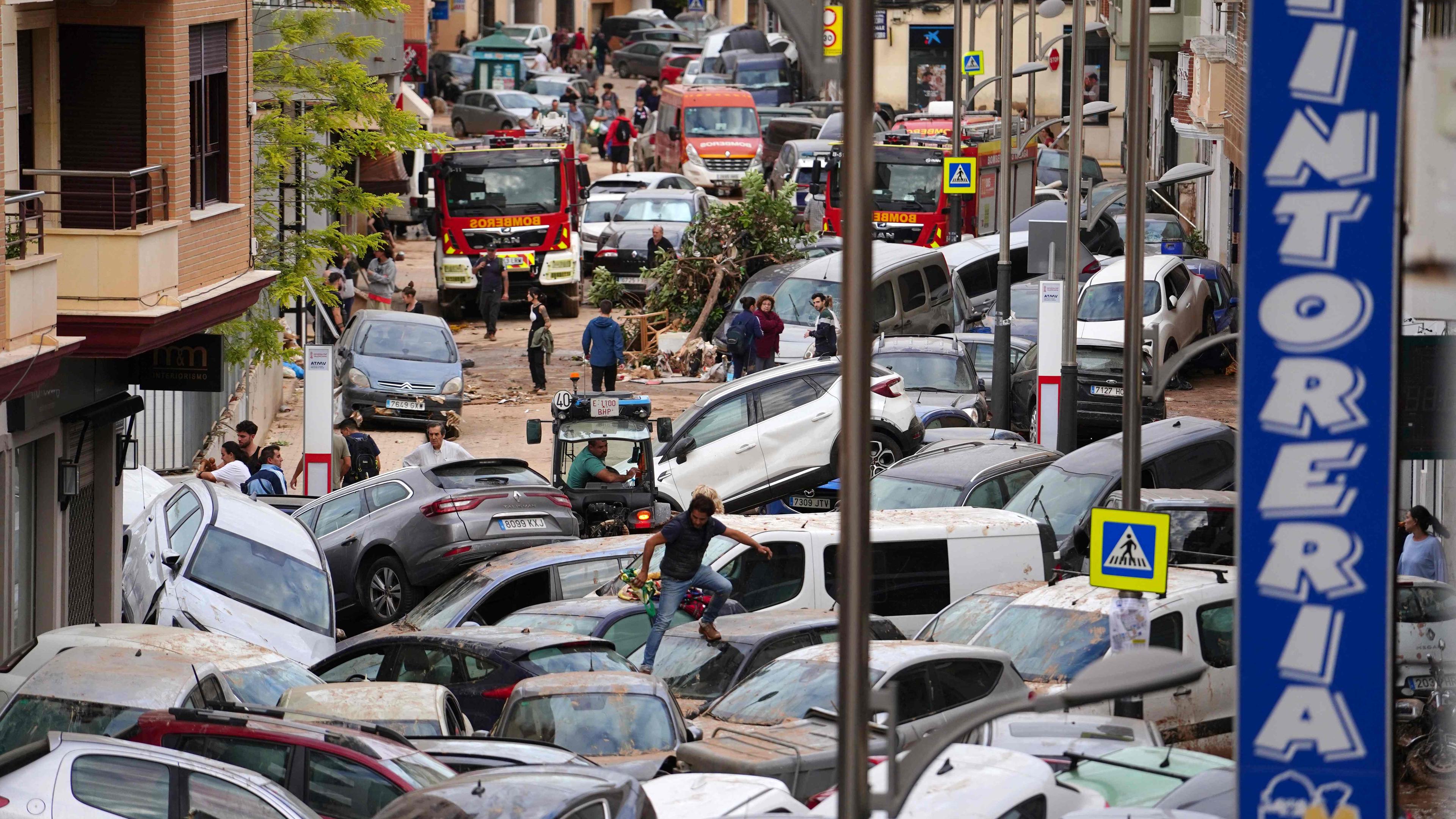 Nach den schweren Unwettern mit Überschwemmungen stapeln sich in einer Straße in Sedavi, südlich von Valencia, die Autos.