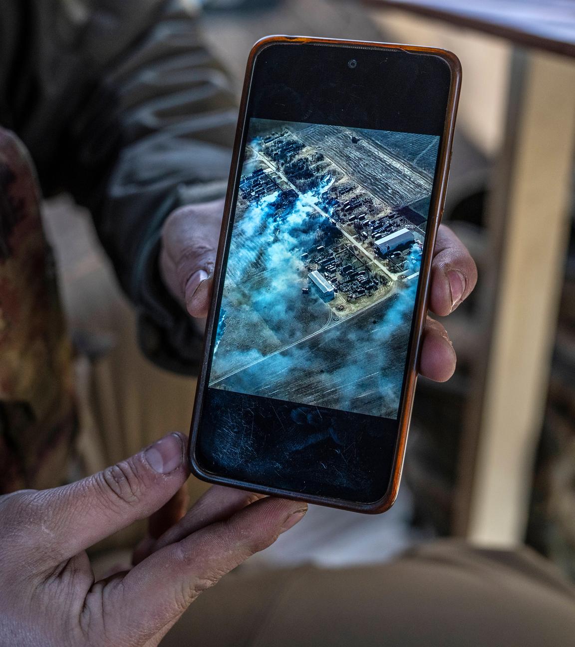 Ein Mitglied der ukrainischen Luftangriffsbrigade zeigt ein Foto eines früheren erfolgreichen Angriffs auf russische Truppen an einer Position im Donbas