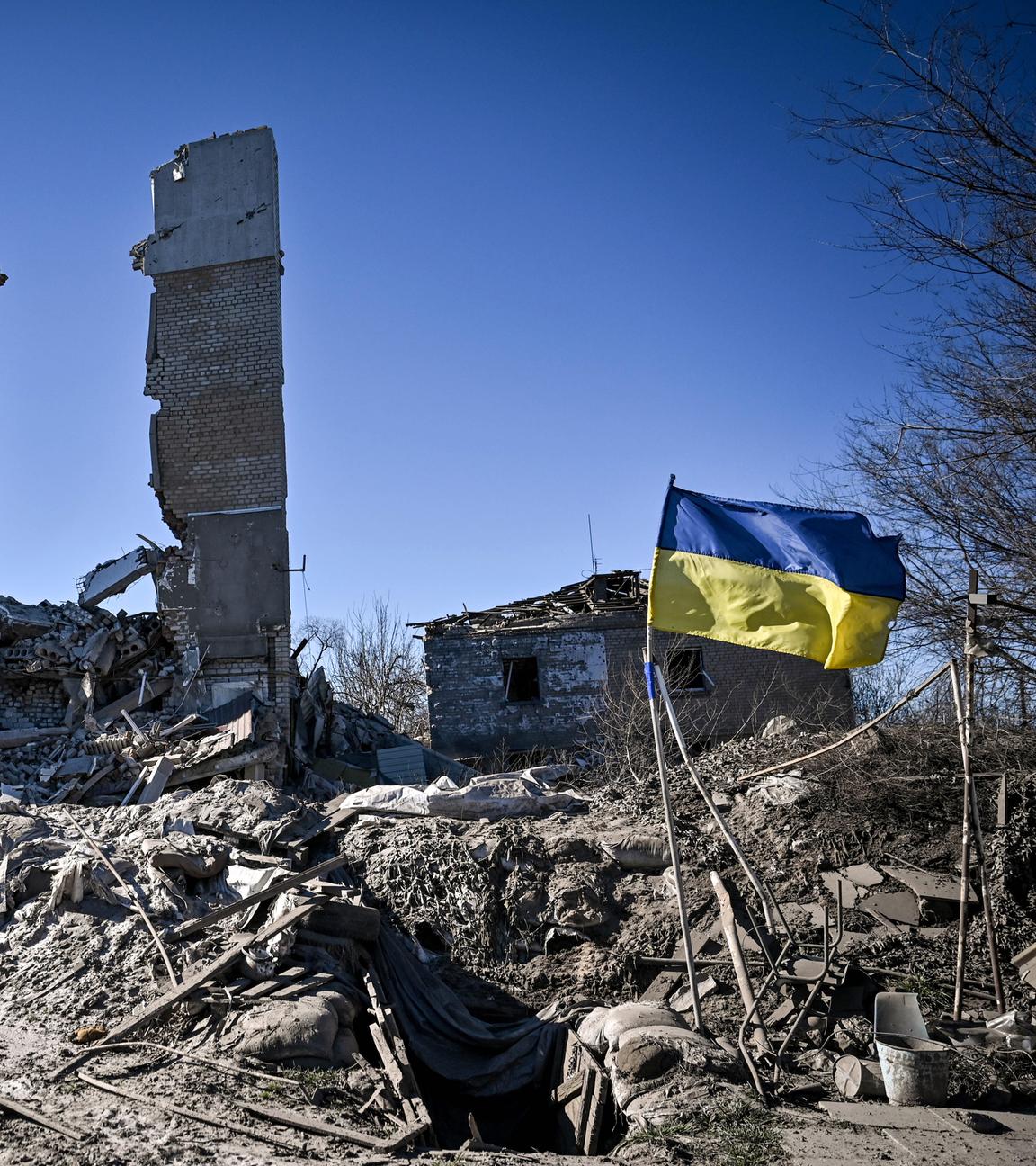 A Ukrainian flag flutters in the wind outside a five-storey residential building destroyed in Russian shelling,