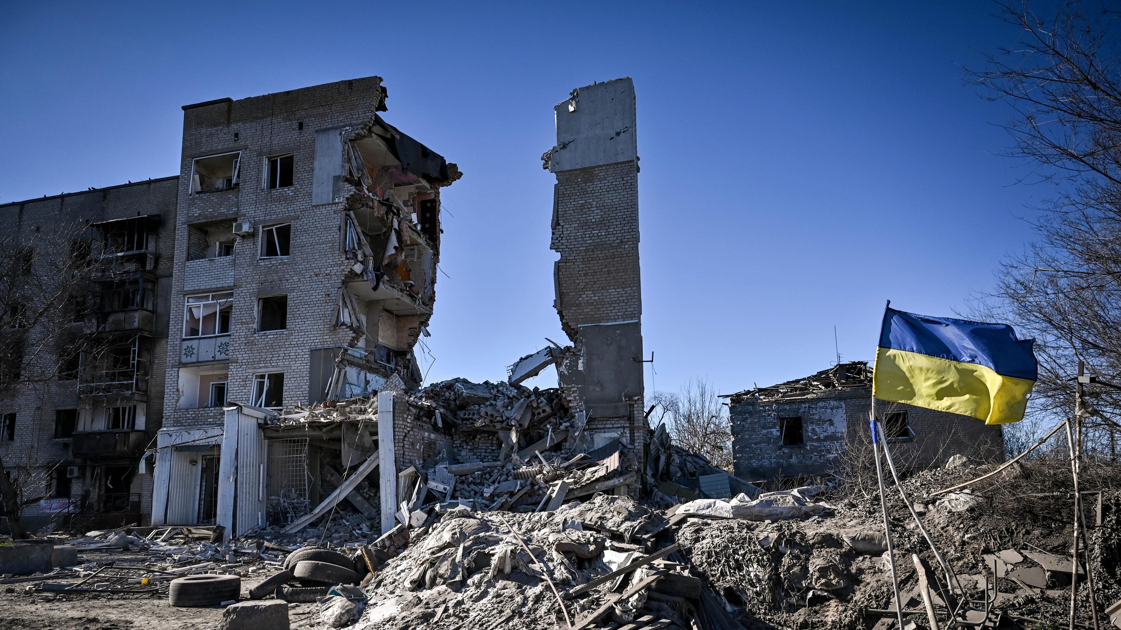 A Ukrainian flag flutters in the wind outside a five-storey residential building destroyed in Russian shelling,