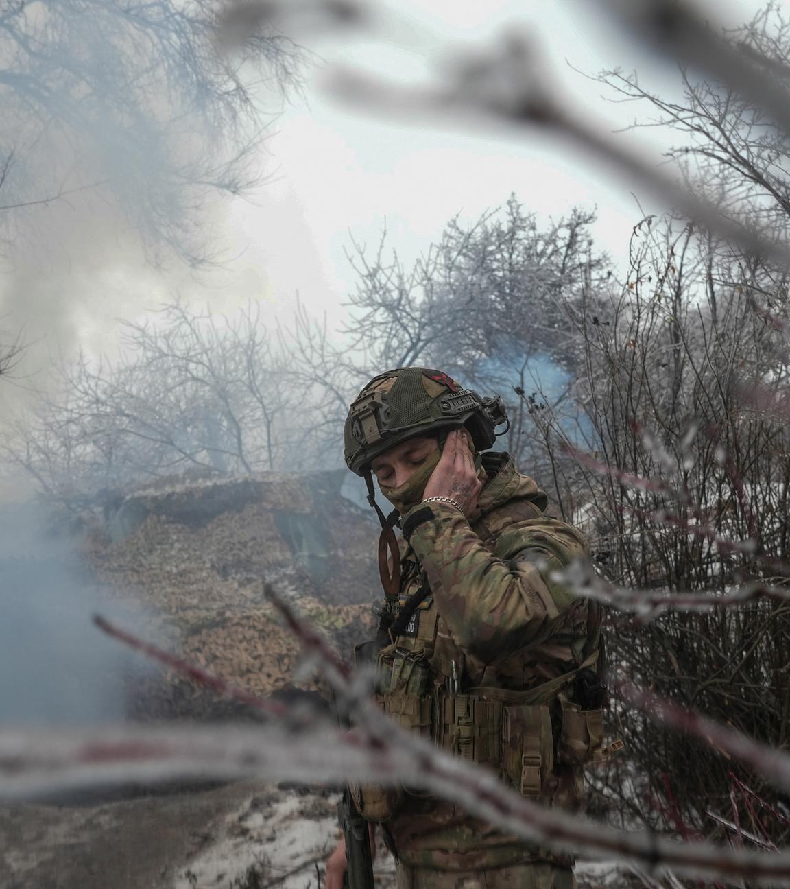 Ein ukrainischer Soldat hält sich das Ohr zu, während eine Panzerhaubitze 2S1 Gvozdika auf russische Truppen an der Frontlinie in der Nähe der Stadt Bakhmut feuert am 15.12.2023.