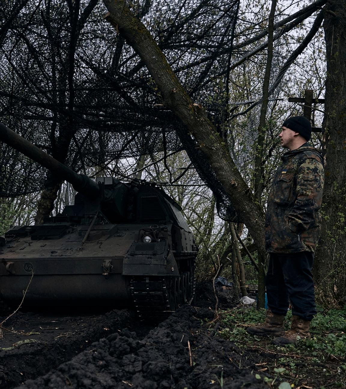 Ukraine, Bachmut: Ein ukrainischer Soldat steht neben einer deutschen Panzerhaubitze 2000, ein selbstfahrendes gepanzertes Artilleriegeschütz, in seiner Stellung an der Frontlinie.