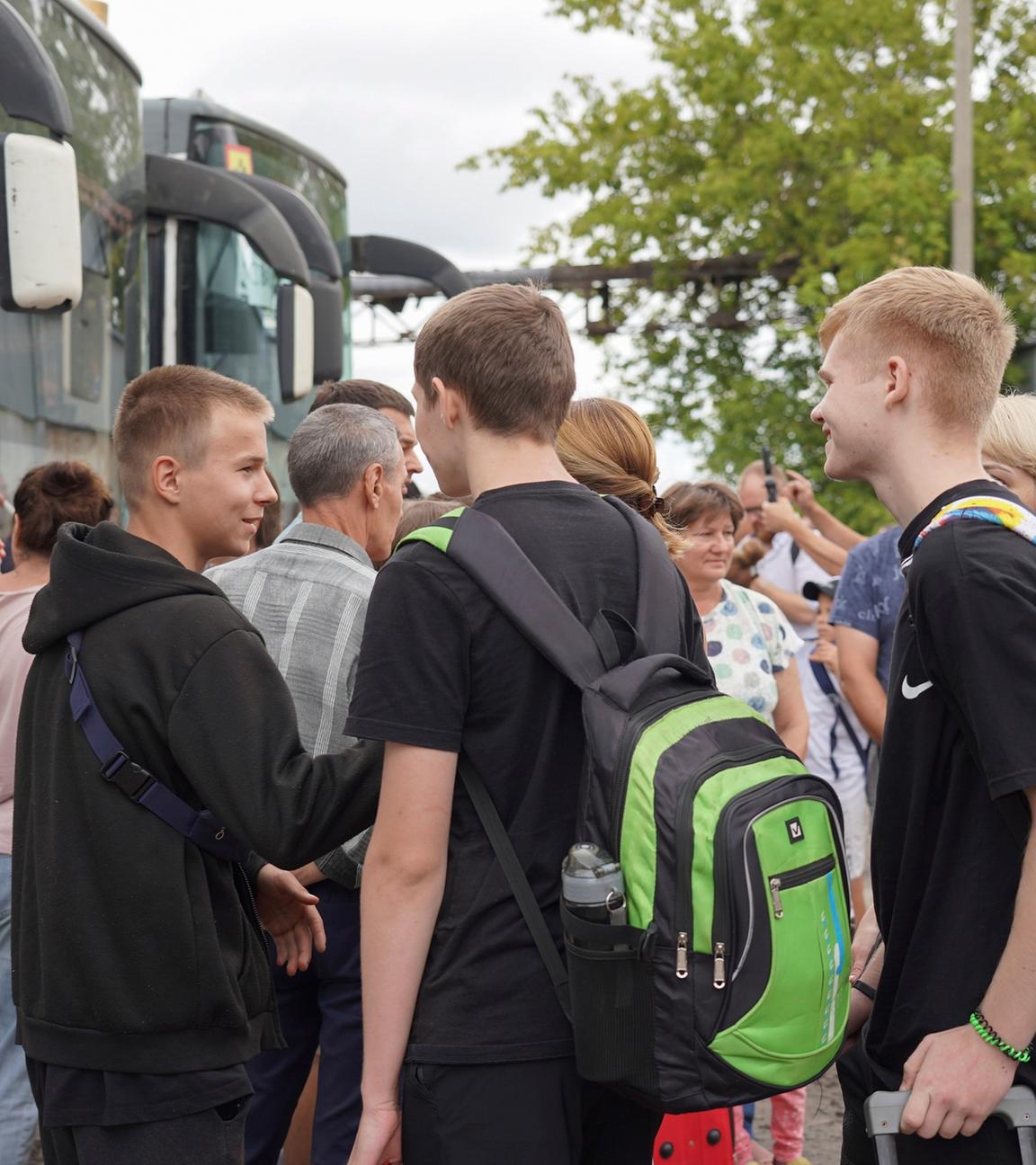 Menschen aus der Region Kursk warten auf die Abfahrt von Bussen, mit denen sie evakuiert werden. 