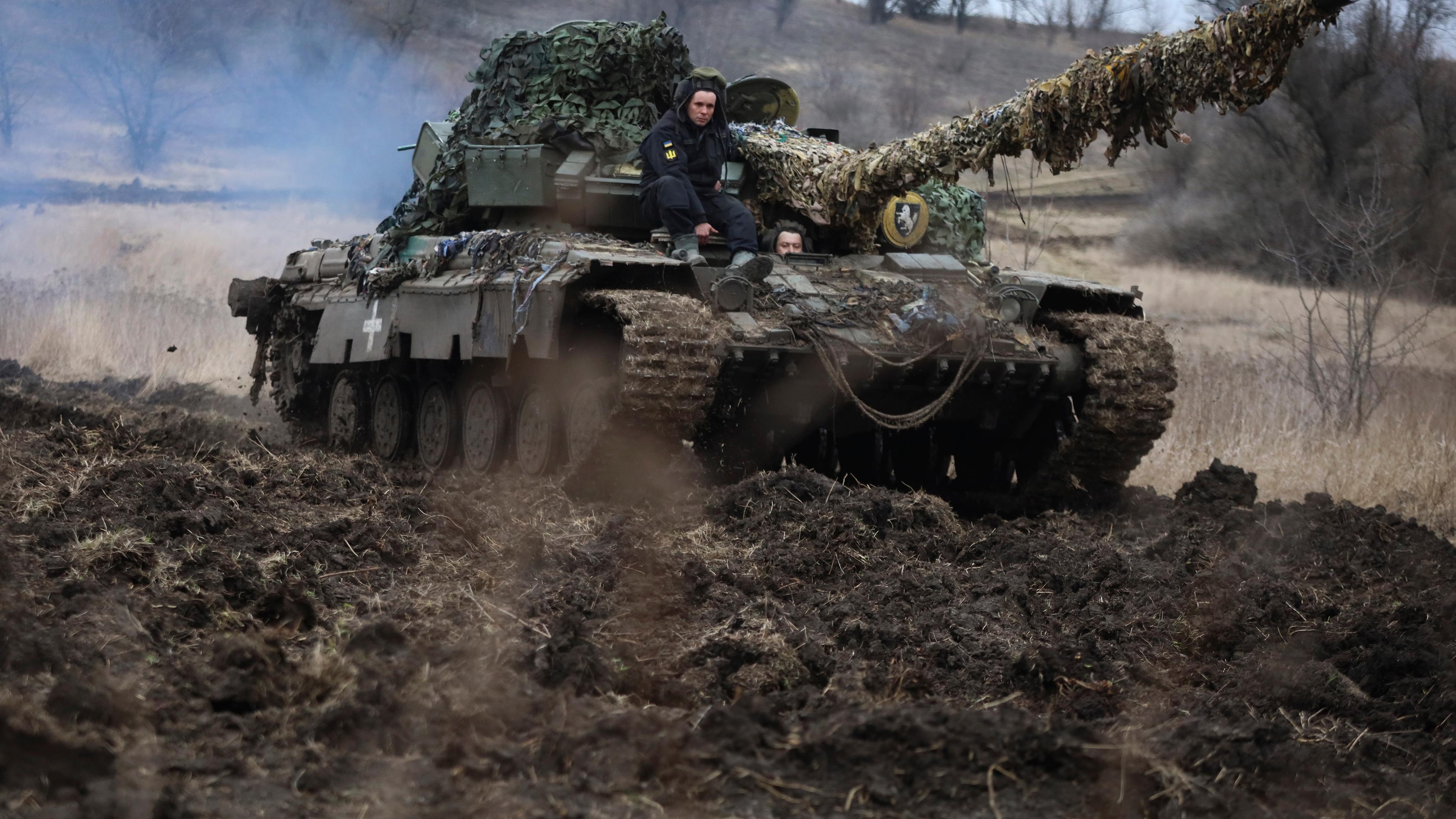 Ukrainische Soldaten fahren auf einem Militärstützpunkt einen Panzer