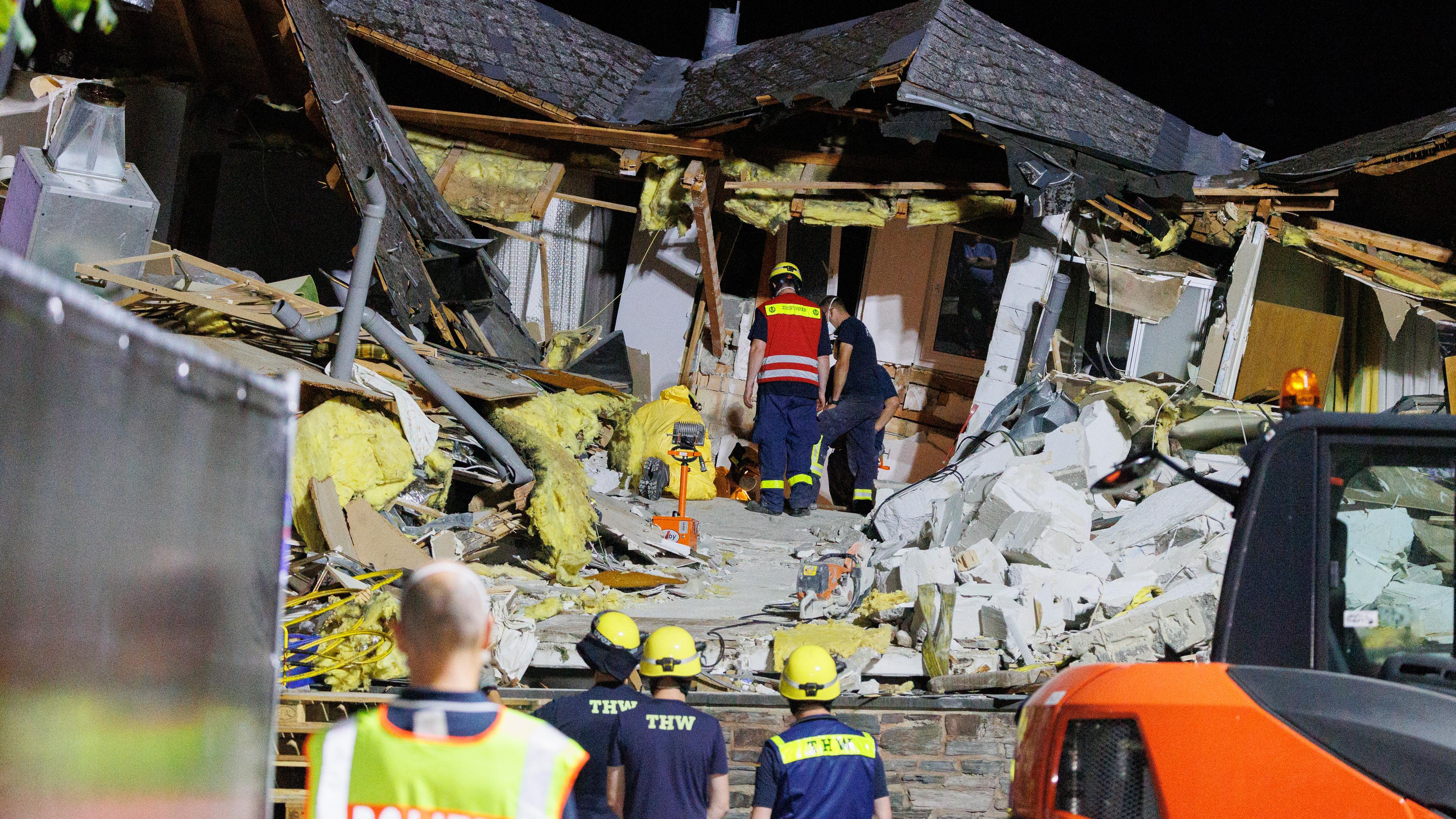 Feuerwehrleute und THW-Helfer räumen Trümmer beiseite, um an den letzten noch verschütteten Toten zu gelangen.