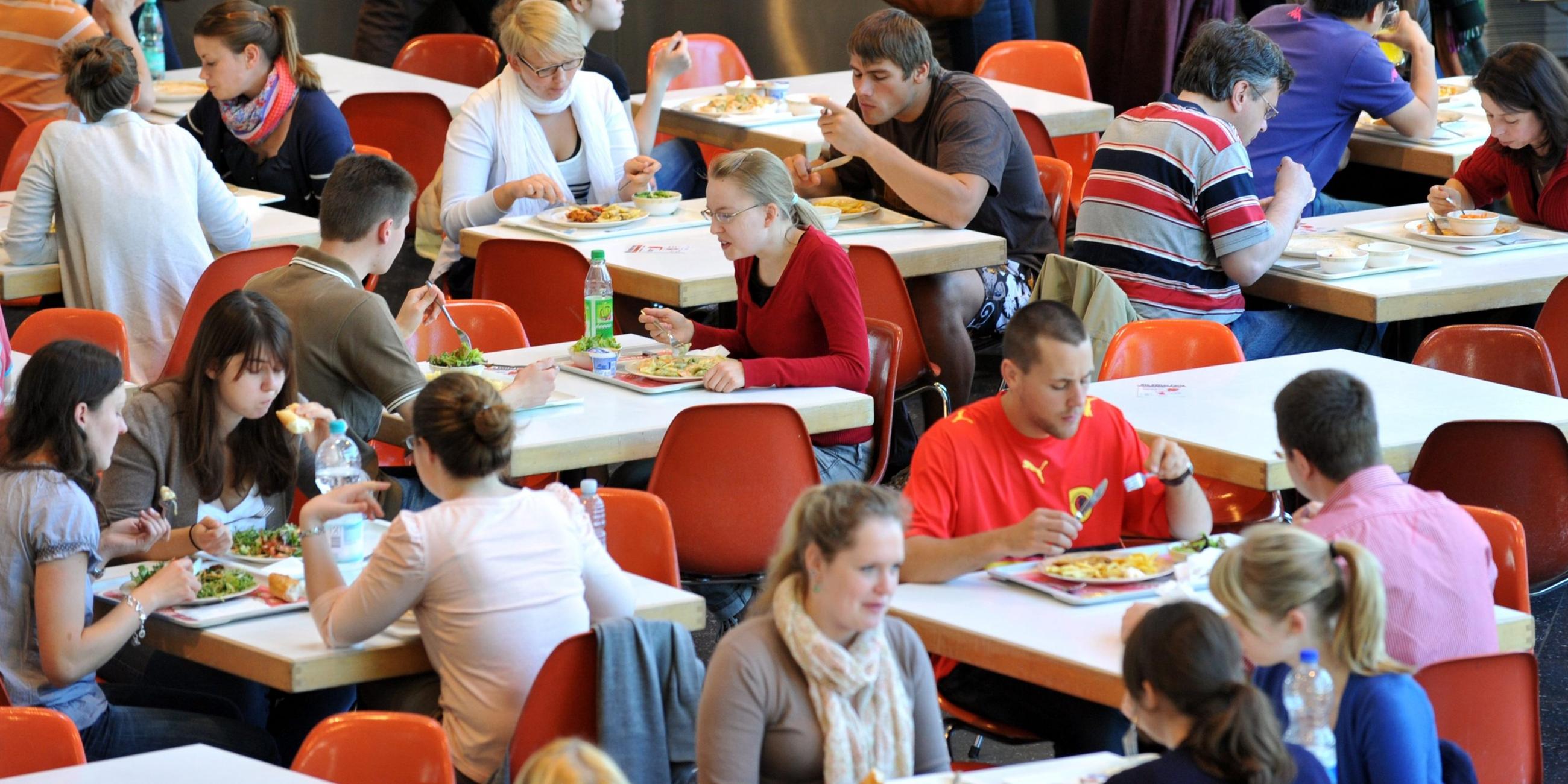 Studenten nehmen in der Mensa der Universität in Freiburg ihr Mittagessen ein