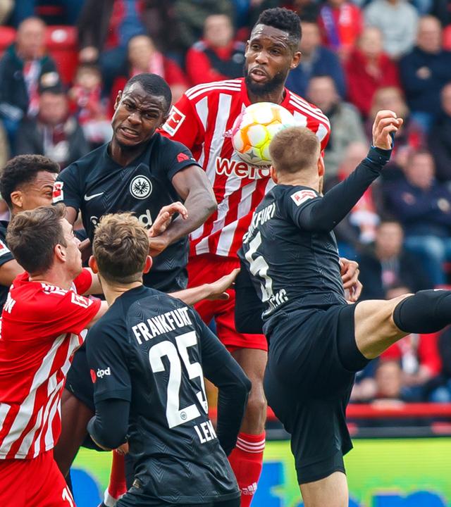 19.03.2023, Berlin: Fußball: Bundesliga, 1. FC Union Berlin - Eintracht Frankfurt, 25. Spieltag, An der Alten Försterei. Unions Jordan Siebatcheu (2.v.r) kämpft mit Frabkfurts Spielern Hrvoje Smolcic (r) und Randal Kolo Muani (3.v.l) um den Ball.