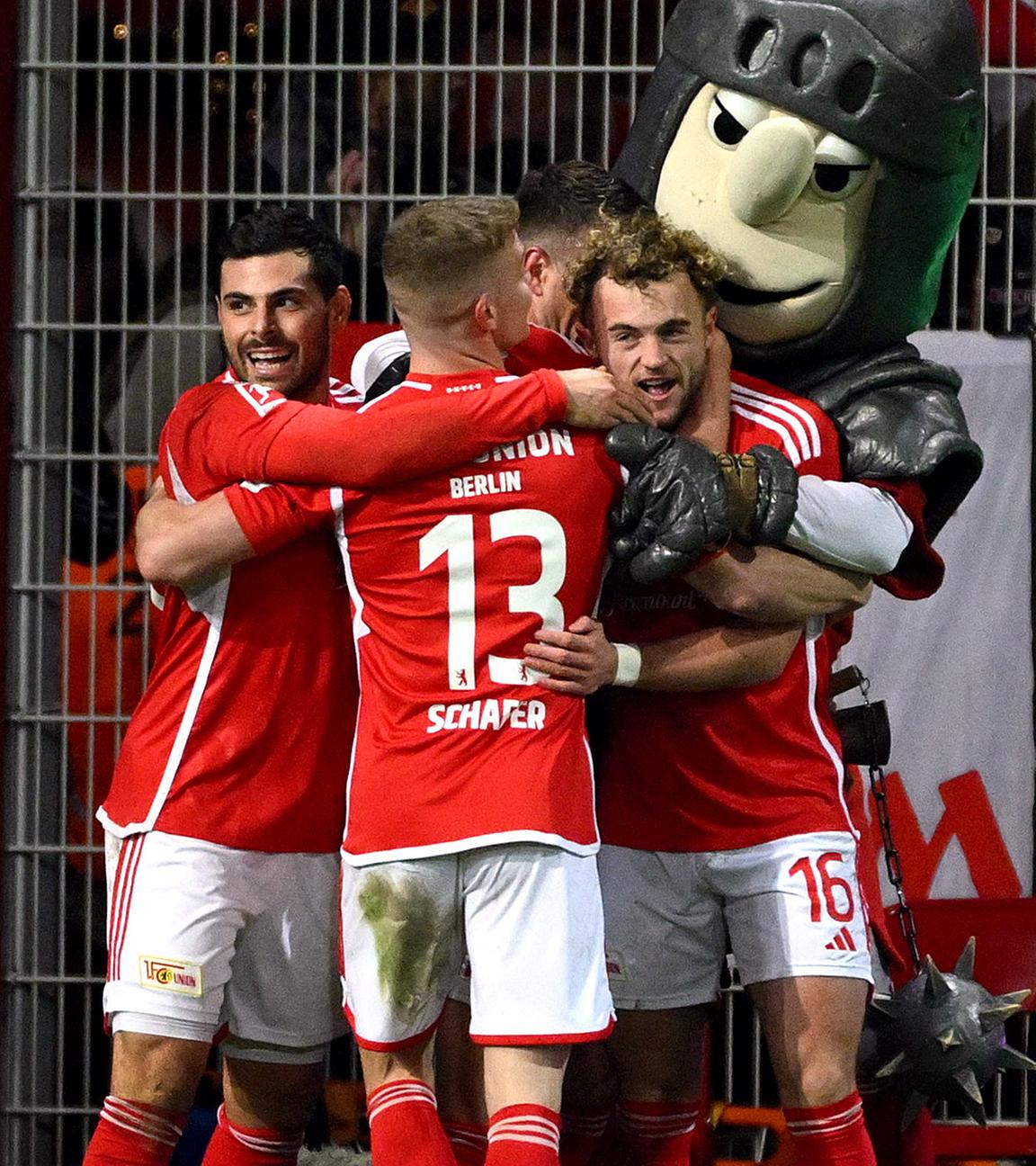 1. FC Union Berlin, Benedict Hollerbach, feiert seinen ersten Treffer mit Teamkollegen und dem Maskottchen.