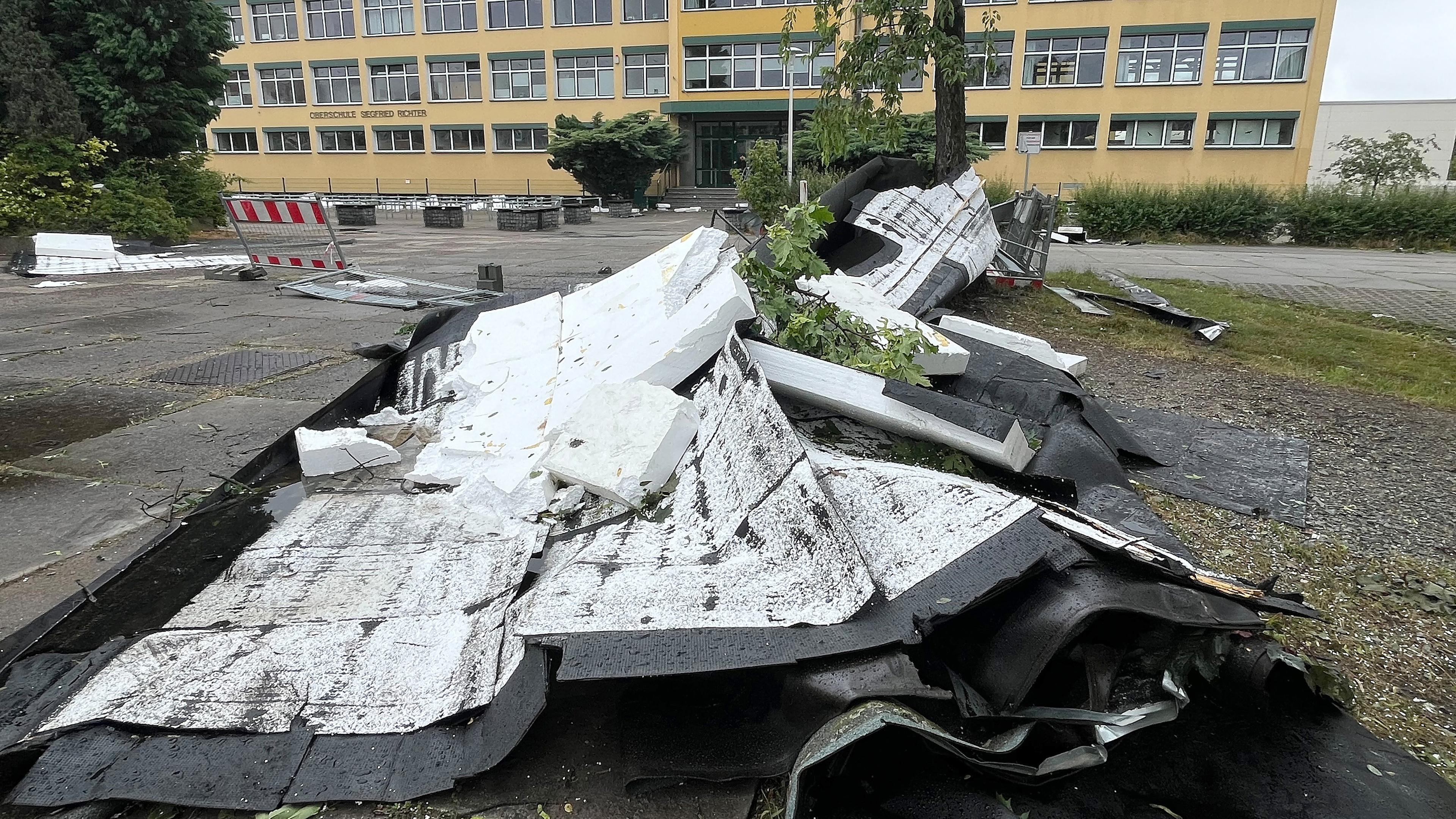 Dachplanen der Oberschule "Siegfried Richter" liegen vor dem Gebäude, aufgenommen am 19.06.2024