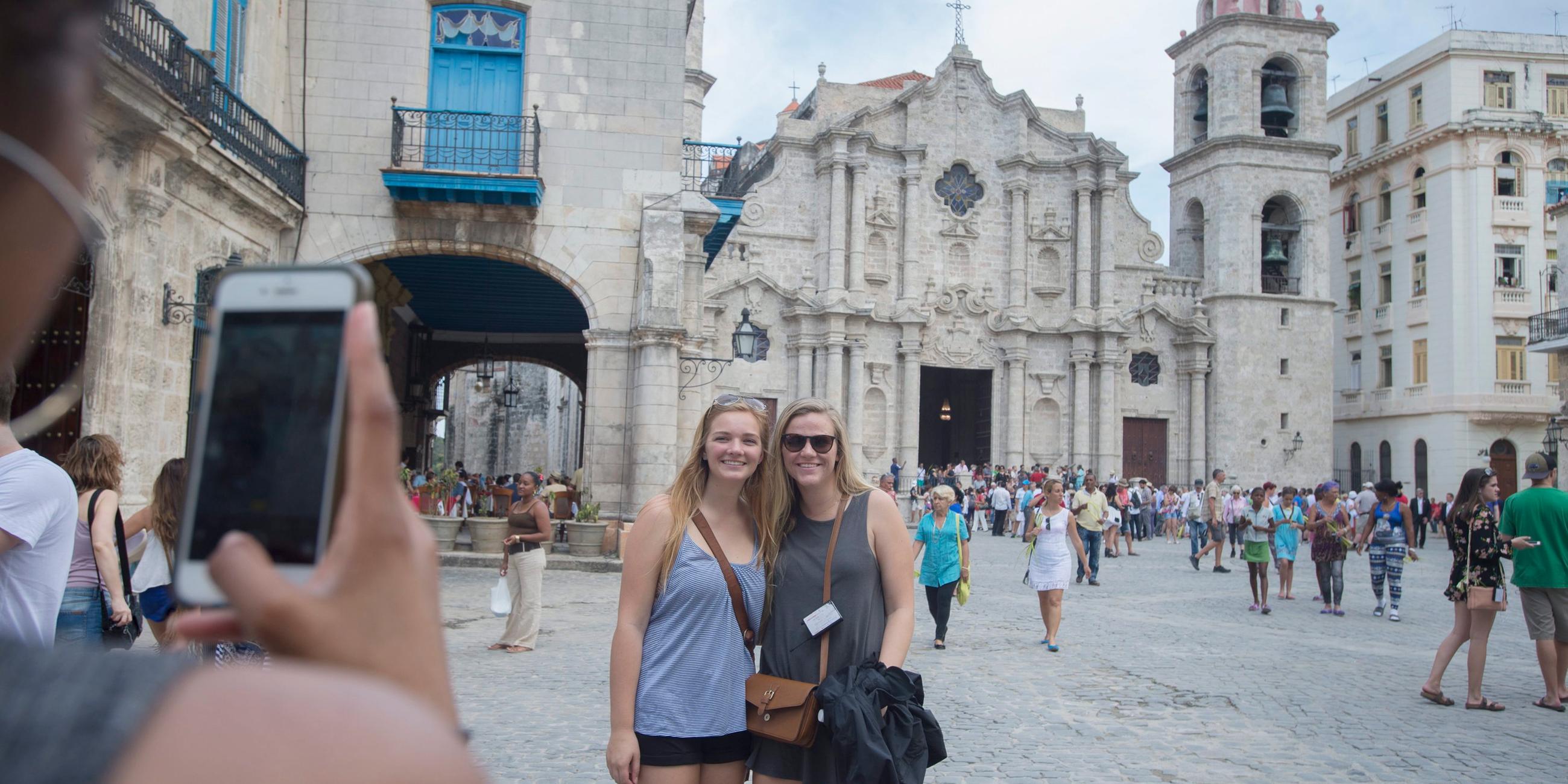 Zwei Frauen lassen sich vor der Kathedrale in Havanna fotografieren.