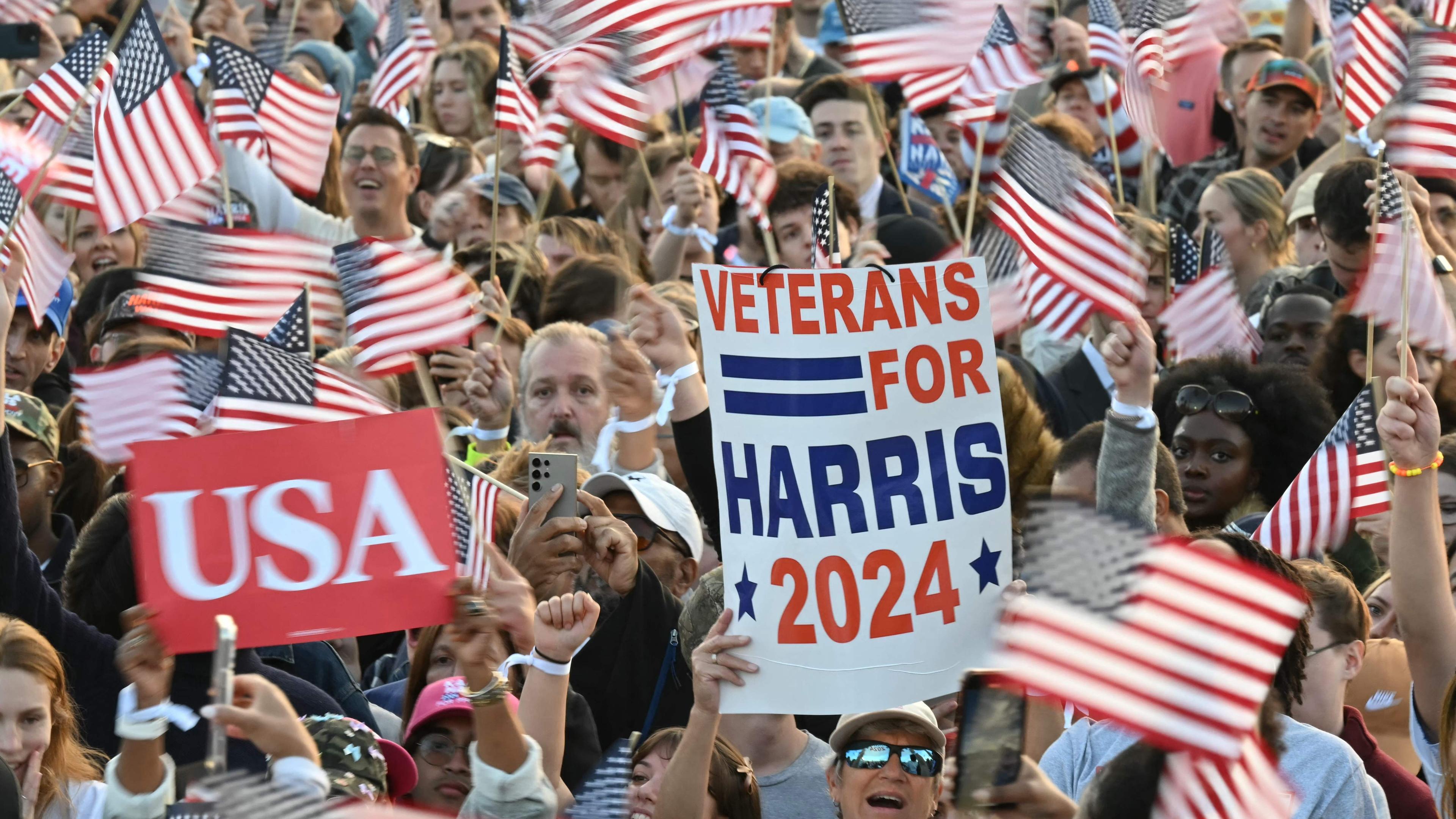 Anhänger von Kamala Harris mit USA-Flaggen und Plakaten. 