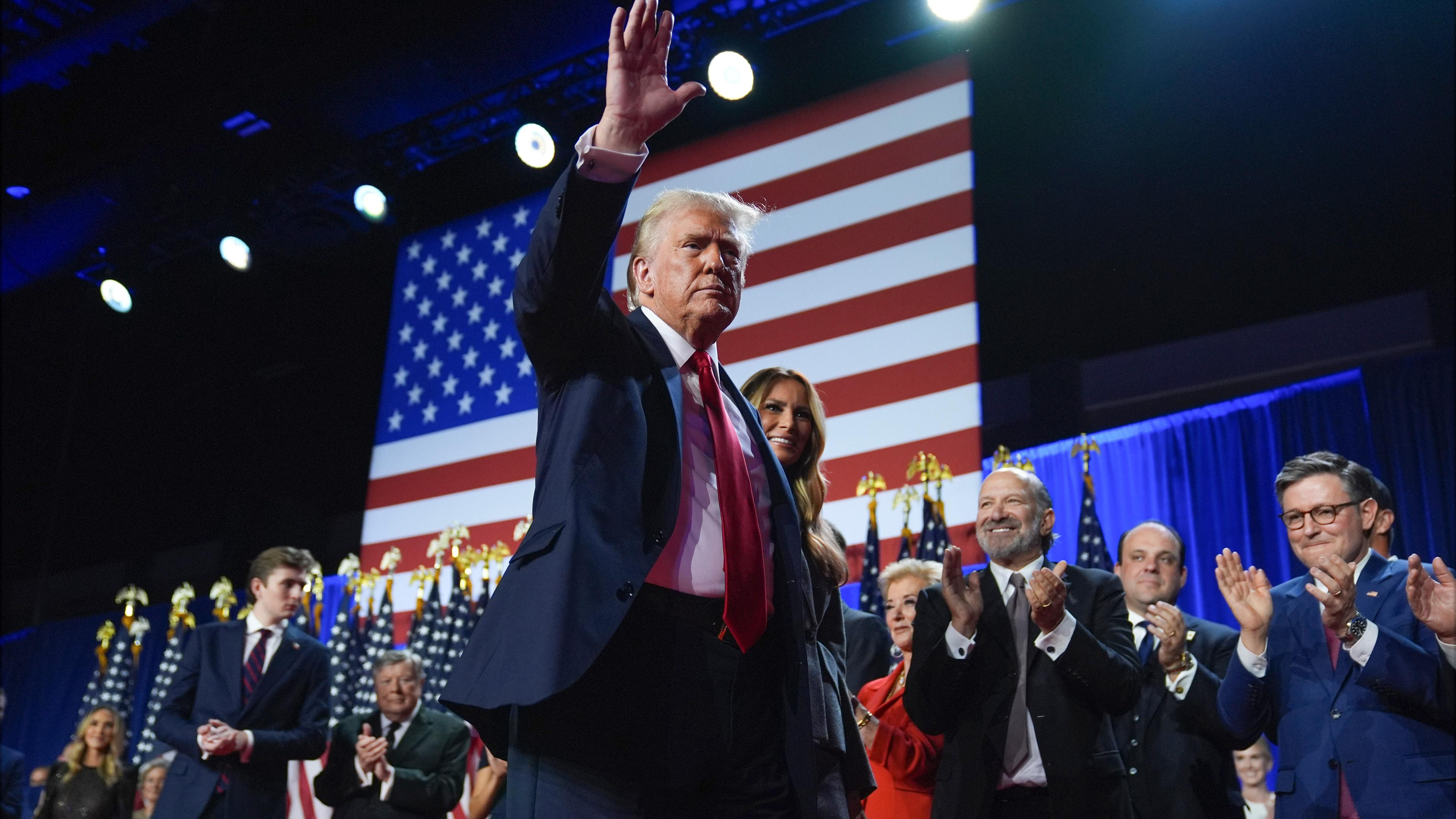 Republican presidential nominee former President Donald Trump waves as he walks with former first lady Melania Trump at an election night watch party at the Palm Beach Convention Center, Wednesday, Nov. 6, 2024, in West Palm Beach, Fla.