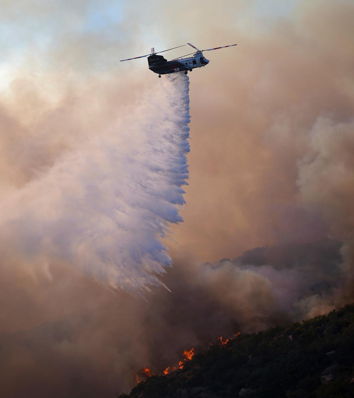 Ein Hubschrauber wirft Wasser auf das Franklin-Feuer in Malibu, USA