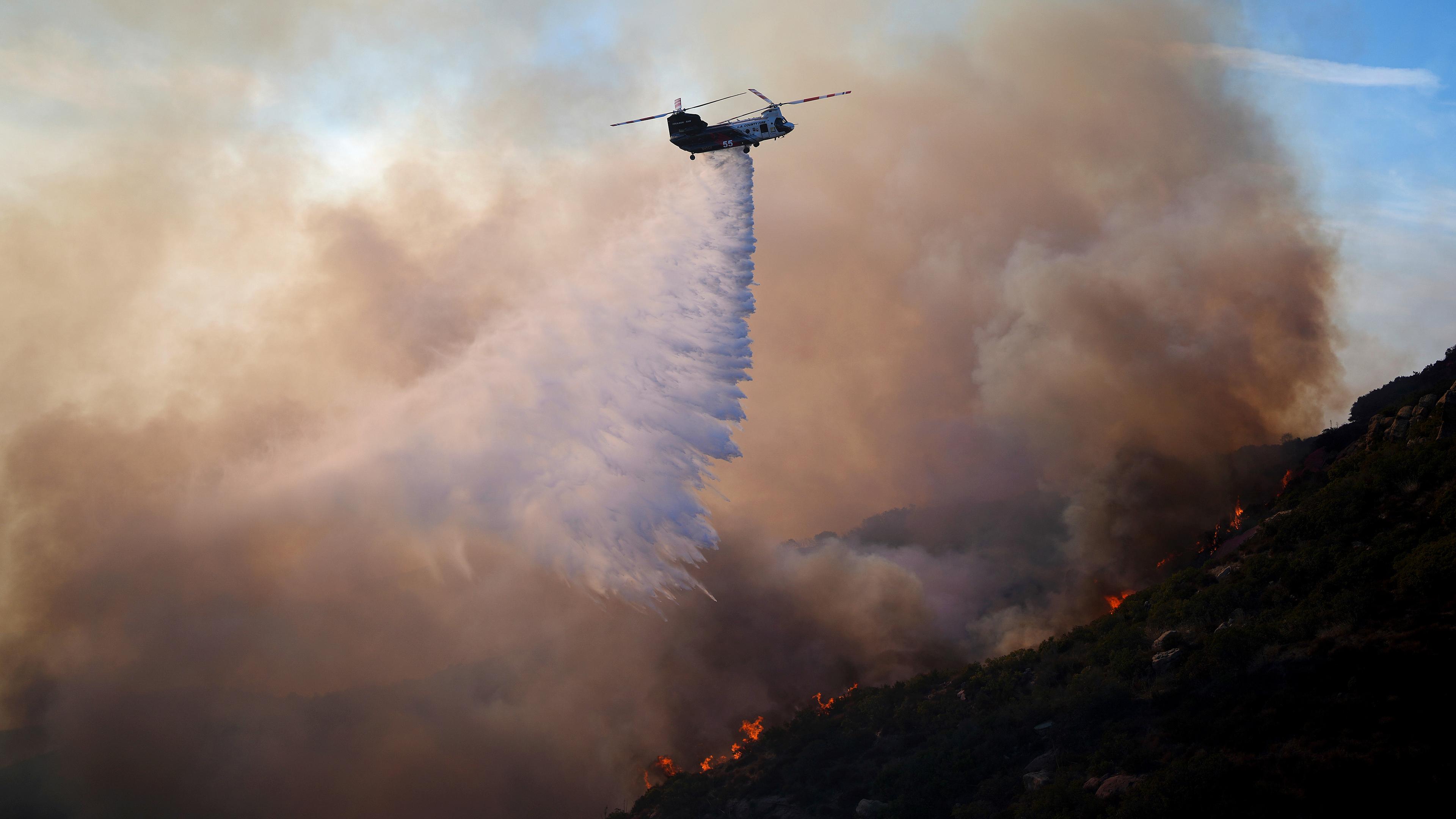 Ein Hubschrauber wirft Wasser auf das Franklin-Feuer in Malibu, USA