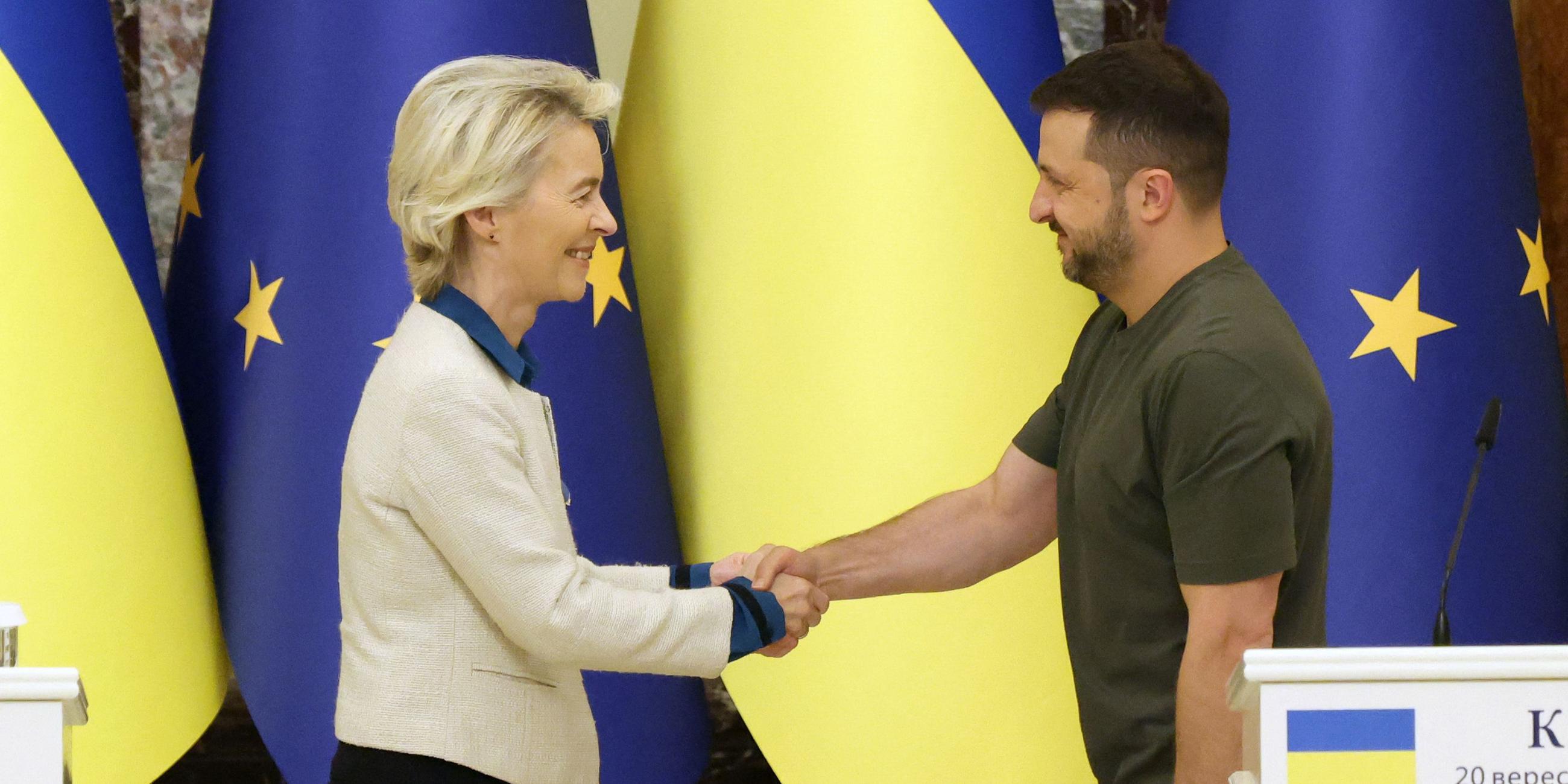 European Commission President Ursula von der Leyen (L) and Ukrainian President Volodymyr Zelensky shake hands after a joint